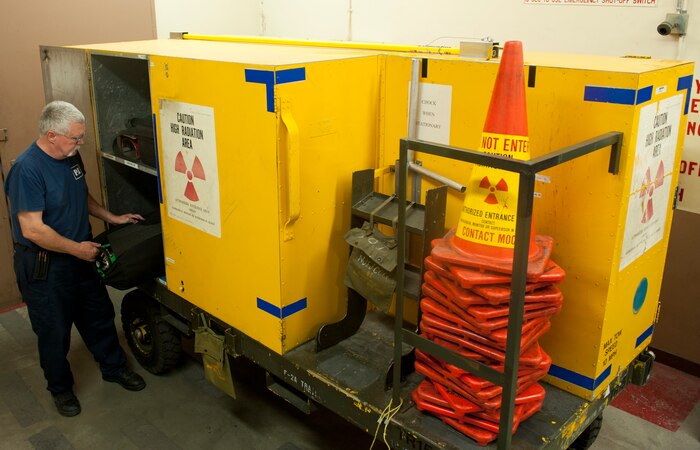 John Sanders, a contractor with the 57th Maintanence Group, prepares the Nondestructive Inspection Laboratory’s mobile x-ray equipment at Nellis Air Force Base, Nev., Aug. 11. As part of safety measures, the NDI Lab places cones in front of all doors, hangs up signs, and has flashing red lights as a warning so people know they’re using x-ray equipment. (U.S. Air Force photo by Airman 1st Class Mikaley Towle)