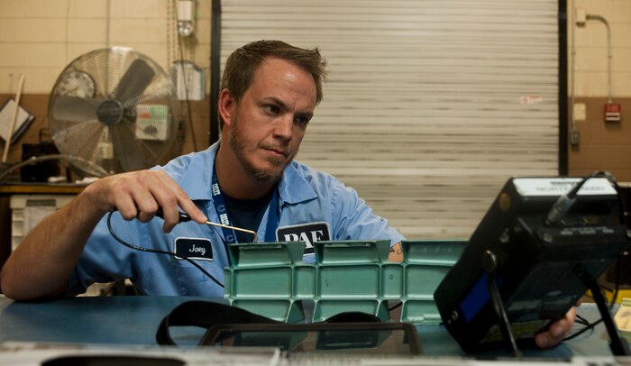Joey Mabrey, a contractor with the 57th Maintanence Group, looks for abnormalities on and around an aircraft part using an eddy current, at the Nondestructive Inspection Laboratory on Nellis Air Force Base, Nev., Aug. 11. Mabrey uses the information received during the current to find cracks or abnormalities in aircraft material on Nellis AFB aircraft. (U.S. Air Force photo by Airman 1st Class Mikaley Towle)