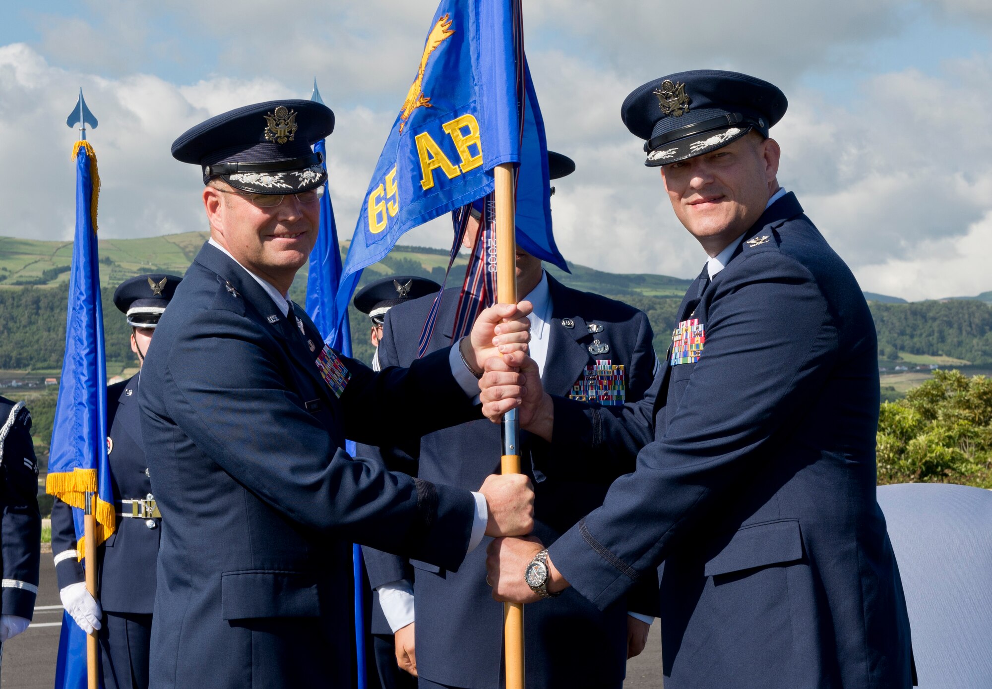 Col. Richard Sheffe, commander of the 65th Air Base Group, receives the guidon from Brig. Gen. Jon Thomas, commander of the 86th Airlift Wing, Ramstein Air Base, Germany. Sheffe assumes command of the 65th Air Base Group during a Redesignation Ceremony on Lajes Field, Azores, Portugal, August 14, 2015. With this Redesignation Ceremony, the 65th Air Base Group is now aligned under the 86th Airlift Wing and remains positioned to provide agile combat support and services to aircraft and aircrews. (U.S. Air Force photo by Master Sgt. Bradley C. Church)
