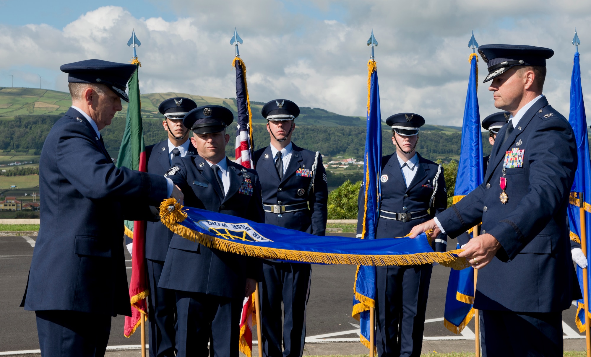 Lt. Gen. Timothy Ray, commander of the Third Air Force and 17th Expeditionary Air Force, and Col. Martin Rothrock, commander of the 65th Air Base Wing, furl and encase the 65th Air Base Wing flag during a Redesignation Ceremony on Lajes Field, Azores, Portugal, August 14, 2015. With this Redesignation Ceremony the 65th Air Base Group is now aligned under the 86th Airlift Wing and remains positioned to provide agile combat support and services to aircraft and aircrews. (U.S. Air Force photo by Master Sgt. Bradley C. Church)
