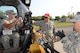 Training cadre instructor Staff Sgt. Christopher Larson, of the 119th Civil Engineer Squadron, in red cap, provides operating instruction for connecting hydraulic lines of an asphalt mill to a skid steer loader for visiting members of the 121st Air Refueling Wing from left to right Senior Airman Joel Coppola and Staff Sgt. Shane Hatfield at the North Dakota Air National Guard Regional Training Site, Fargo, North Dakota, August 14, 2015. The North Dakota Air National Guard Regional Training Site is one of five contingency training locations in the United States used by Air National Guard and U.S. Air Force personnel in the civil engineer career fields. I provides wartime mission training as well as proficiency training on construction practices, utility support, emergency services, maintenance and repair of base infrastructure. Four separate groups totaling about 400 people are scheduled to train at the site in the month of August in 2015. (U.S. Air National Guard photo by Senior Master Sgt. David H. Lipp/Released)