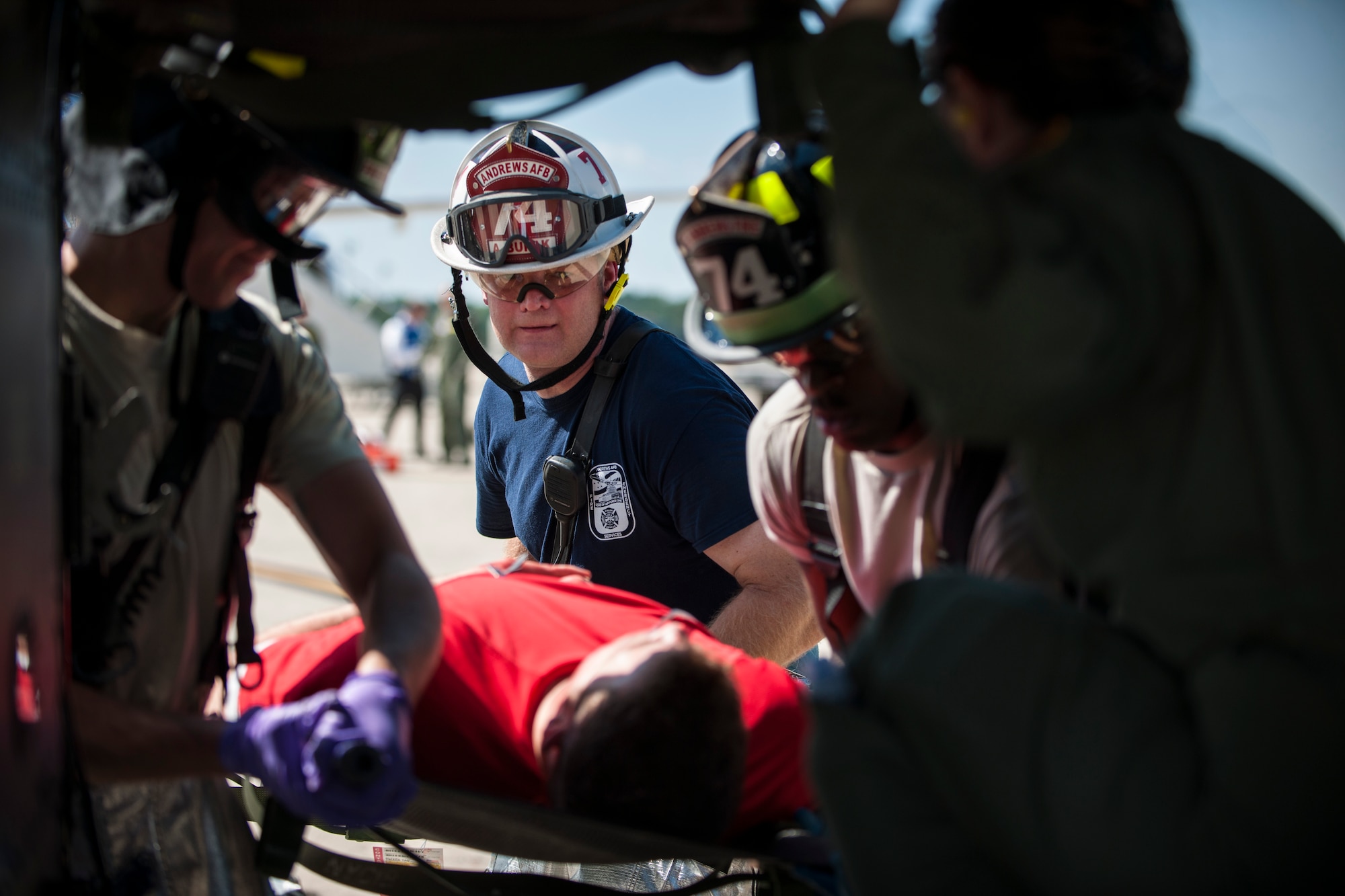 Adam Burak, 11th Wing fire department crew chief, and other first responders, load a simulated patient onto a UH-1N Huey during an emergency-readiness exercise on the flight line of Joint Base Andrews, Md., Aug. 13, 2015. The 11th Civil Engineer Squadron fire department worked alongside the 11th Security Forces Squadron, 79th Medical Wing and the 1st Helicopter Squadron during the exercise. (U.S. Air Force photo/Airman 1st Class Philip Bryant)