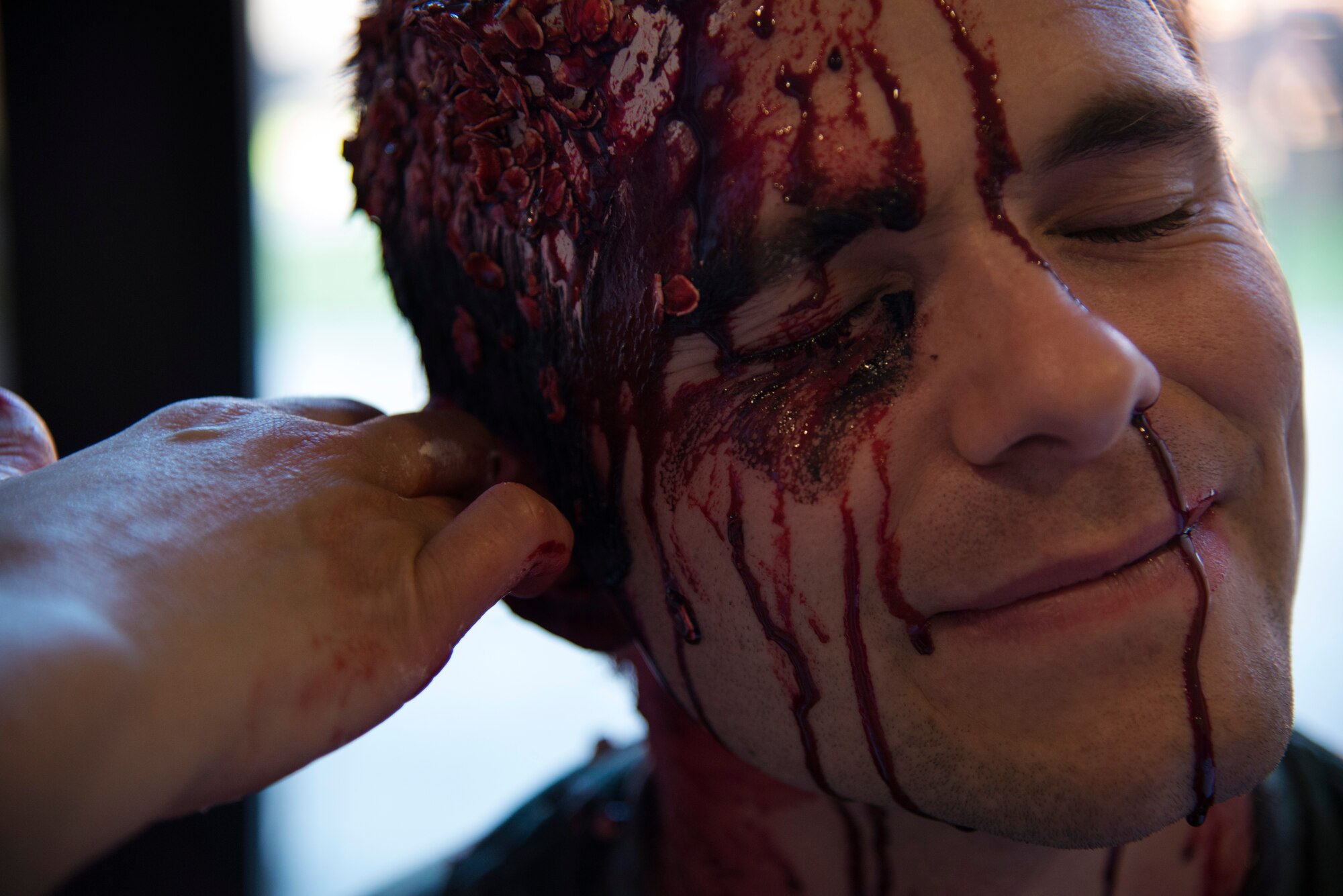 Capt. Jace McCown, exercise volunteer, receives a moulage injury during an emergency-readiness exercise at Joint Base Andrews, Md., Aug. 13, 2015. A combination of moulage, mock injuries and role-player acting created a realistic training environment. (U.S. Air Force photo/Airman 1st Class Philip Bryant)