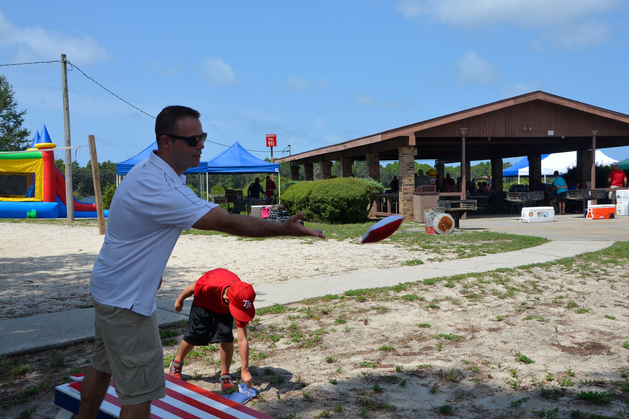Master Sgt. Robert Arthur, executive assistant to the Continental U.S. Aerospace Defense Command – 1st Air Force (Air Forces Northern) Command Chief, tosses a bean bag in the corn hole game during 1st Air Force (Air Forces Northern)’s “Family Day 2015” Aug. 7 at Bonita Bay. The day focused on taking care of the organization’s families and featured a variety of activities that included food and sport competitions, a waterslide and plenty to eat and drink. (Air Force Photo Released/Mary McHale)

