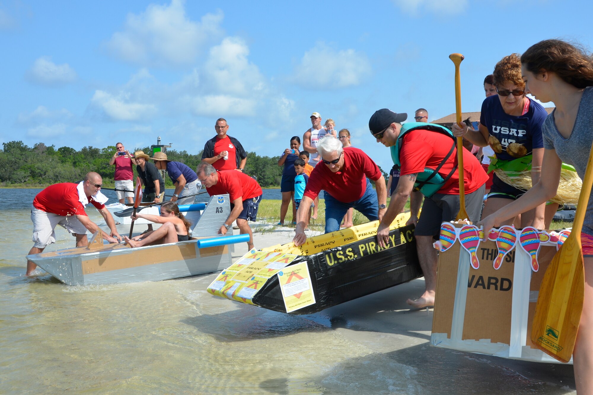 Participants in the 1st Air Force (Air Forces Northern) “Family Day 2015” at Bonita Bay Aug. 7 help contestants in the cardboard boat race get their entries into the water. The race kicked off the day which focused on taking care of the organization’s families and featured a variety of activities that included food and sport competitions, a waterslide and plenty to eat and drink. (Air Force Photo Released/Mary McHale)
