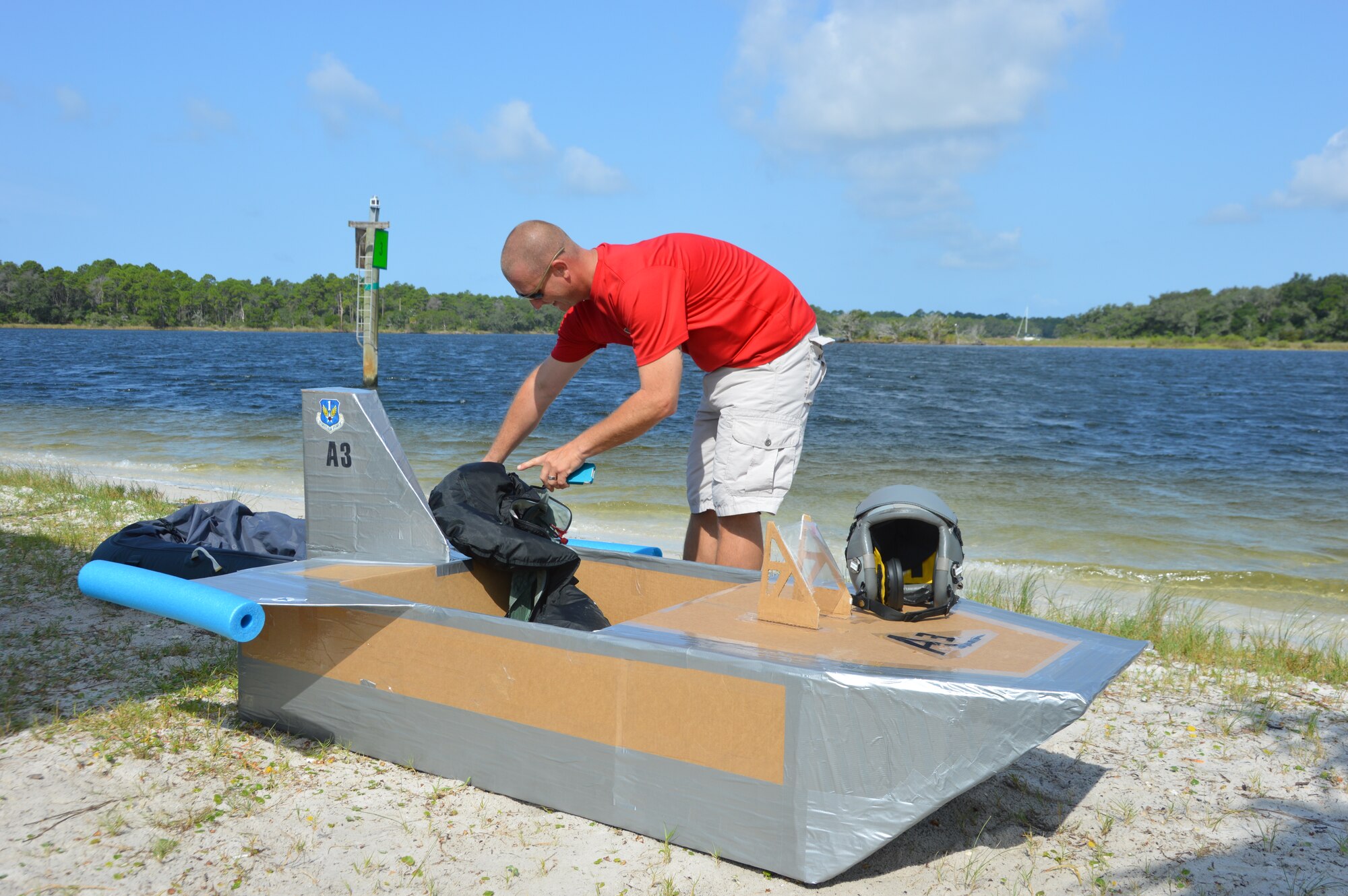 Master Sgt. Joseph Cooper, 1st Air Force (Air Forces Northern) Air, Space & Information Operations Directorate, adjusts some equipment in the A3 entry prior to the cardboard boat race at Bonita Bay Aug. 7 during the 1st AF (AFNORTH) “Family Day 2015.” The race kicked off the day which focused on taking care of the organization’s families and featured a variety of activities that included food and sport competitions, a waterslide and plenty to eat and drink. (Air Force Photo Released/Mary McHale)