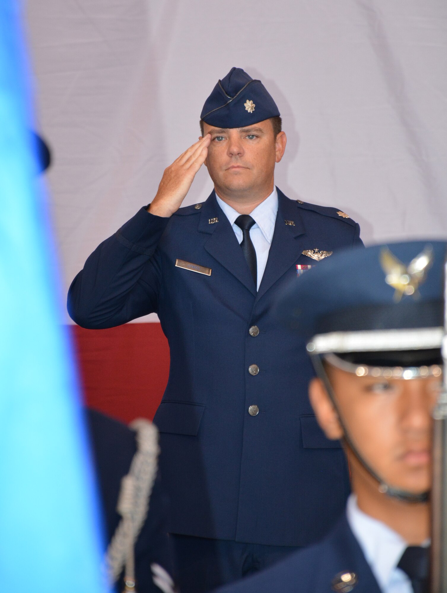Lt. Col. Paul R. Jones pays tribute to the U.S. flag prior to assuming command of the 552nd Training Squadron in a ceremony Aug. 6 in Bldg. 230, Dock 2. Colonel Jones, who comes to the squadron having served previously as the 552nd Air Control Wing director of staff, replaces Lt. Col. Sean Williams. Colonel Williams has accepted a position as a deputy group commander with the 380th Air Expeditionary Wing at Al Dhafra Air Base, United Arab Emirates. Col. Alain Poisson, 552nd Operations Group commander, presided over the ceremony attended by approximately 100 family members, friends and co-workers. (Air Force photo by Darren D. Heusel/Released)