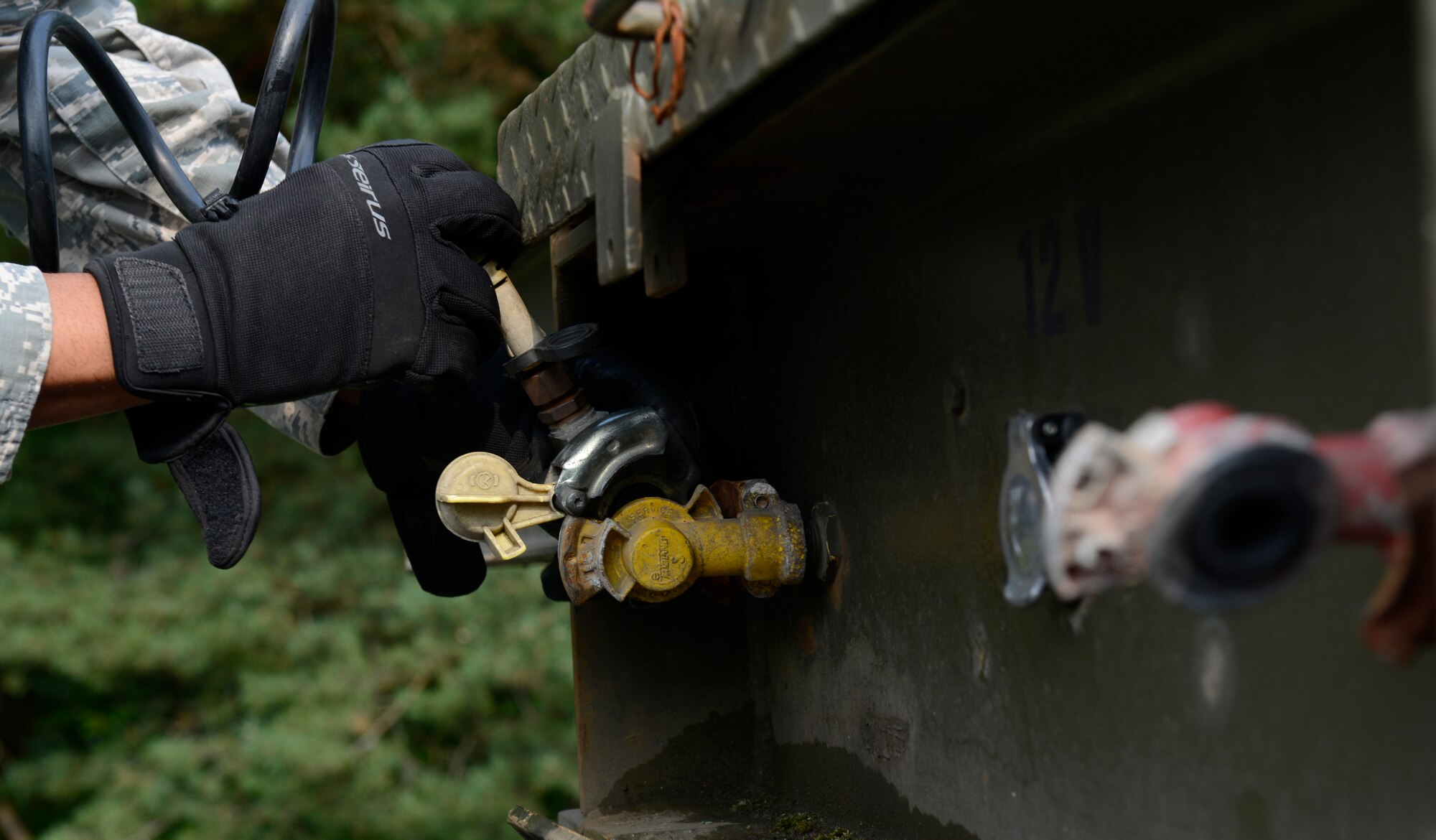 Airman 1st Class Fred Jones, 786th Civil Engineer Squadron heavy equipment operator, connects cables from a tractor trailer vehicle to a flatbed during the Air Force Civil Engineer Center Tractor Trailer Training program Aug. 10, 2015, at Ramstein Air Base, Germany. This is the first time this program is being taught in U.S. Air Forces in Europe, and the program teaches students how to safely drive and maneuver tractor trailers and includes an average of 58 hours of behind-the-wheel training. (U.S. Air Force photo/Airman 1st Class Tryphena Mayhugh)