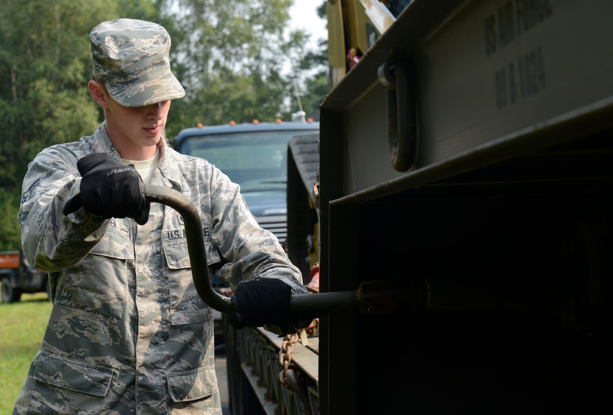 Airman 1st Class Richard Zeren, 786th Civil Engineer Squadron heavy equipment operator, turns a crank to prepare a tractor trailer vehicle from disengaging from a hitch to a flatbed during the Air Force Civil Engineer Center Tractor Trailer Training program Aug. 10, 2015, at Ramstein Air Base, Germany. This is the first time this program is being taught in U.S. Air Forces in Europe, and the program teaches students how to safely drive and maneuver tractor trailers and includes an average of 58 hours of behind-the-wheel training. (U.S. Air Force photo/Airman 1st Class Tryphena Mayhugh) 