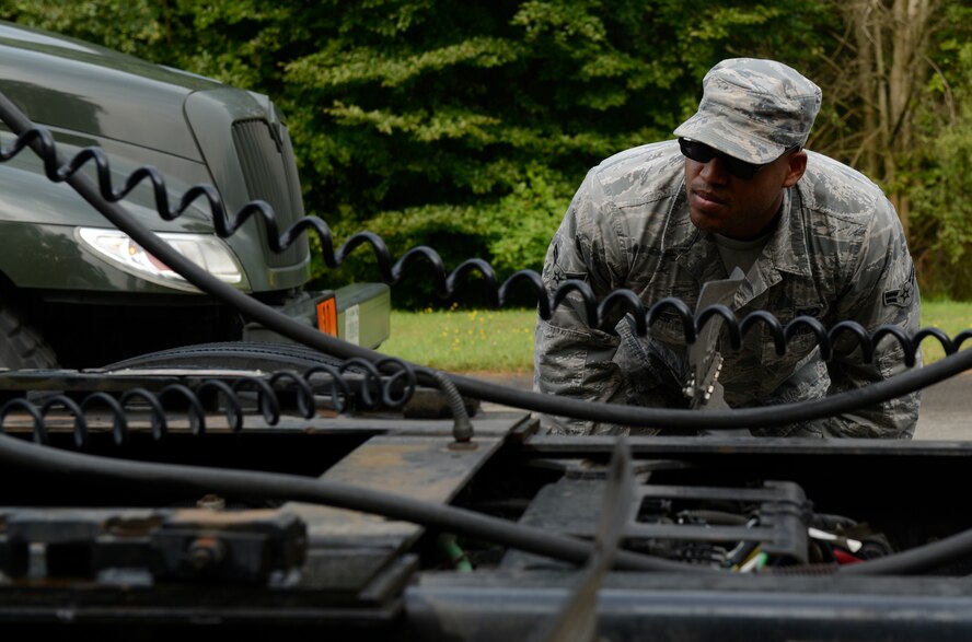 Airman 1st Class Fred Jones, 786th Civil Engineer Squadron heavy equipment operator, looks to make sure a tractor trailer hitch is properly aligned during the Air Force Civil Engineer Center Tractor Trailer Training program Aug. 10, 2015, at Ramstein Air Base, Germany. This is the first time this program is being taught in U.S. Air Forces in Europe, and the program teaches students how to safely drive and maneuver tractor trailers and includes an average of 58 hours of behind-the-wheel training.  (U.S. Air Force photo/Airman 1st Class Tryphena Mayhugh)