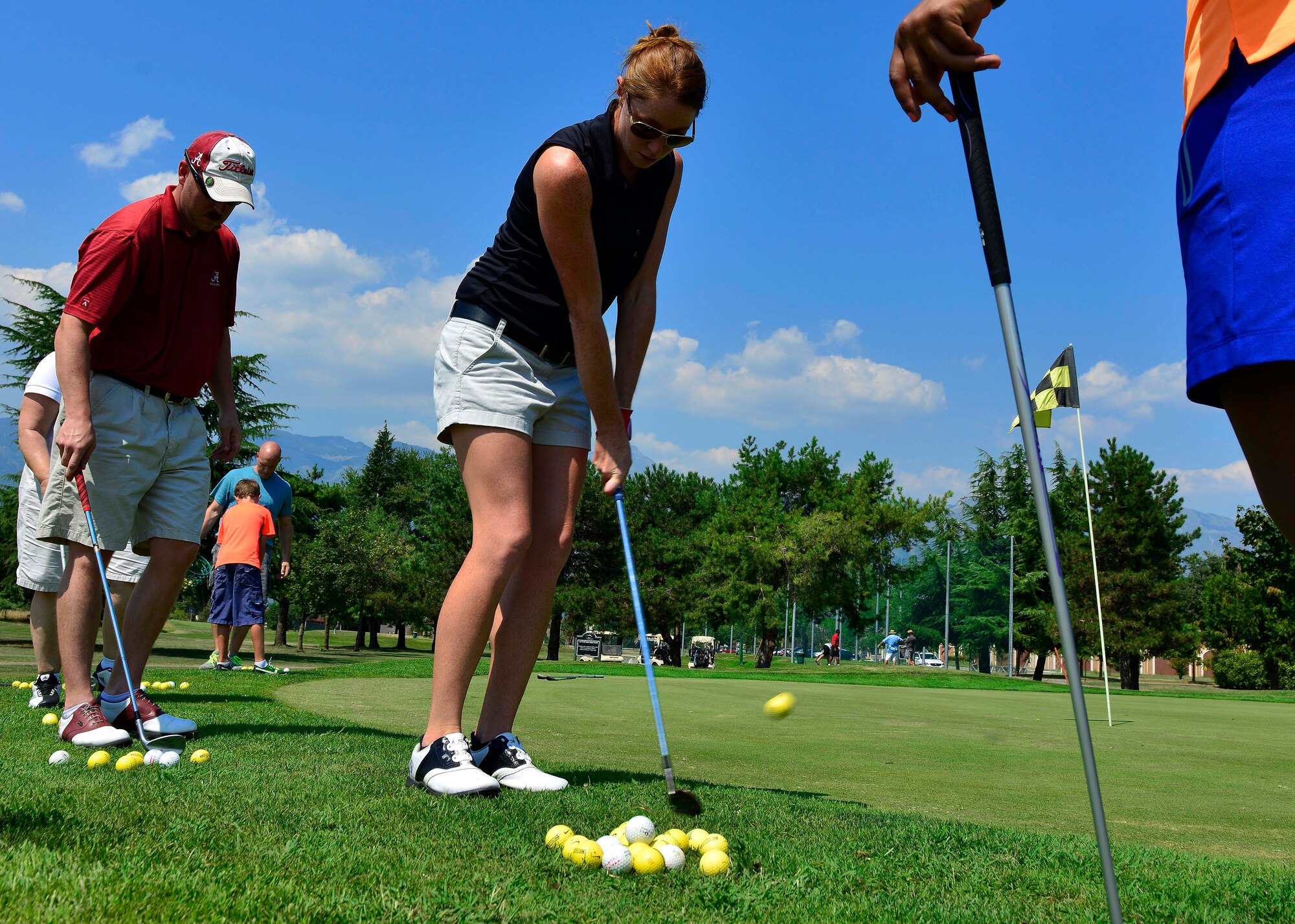 Molly Aronsson, LPGA golfer, demonstrates how to chip a ball onto the green, Aug. 13, 2015, at Aviano Air Base, Italy. Aronsson had a meet-and-greet and provided putting and driving lessons before a tournament. (U.S. Air Force photo by Airman 1st Class Cary Smith/Released)  