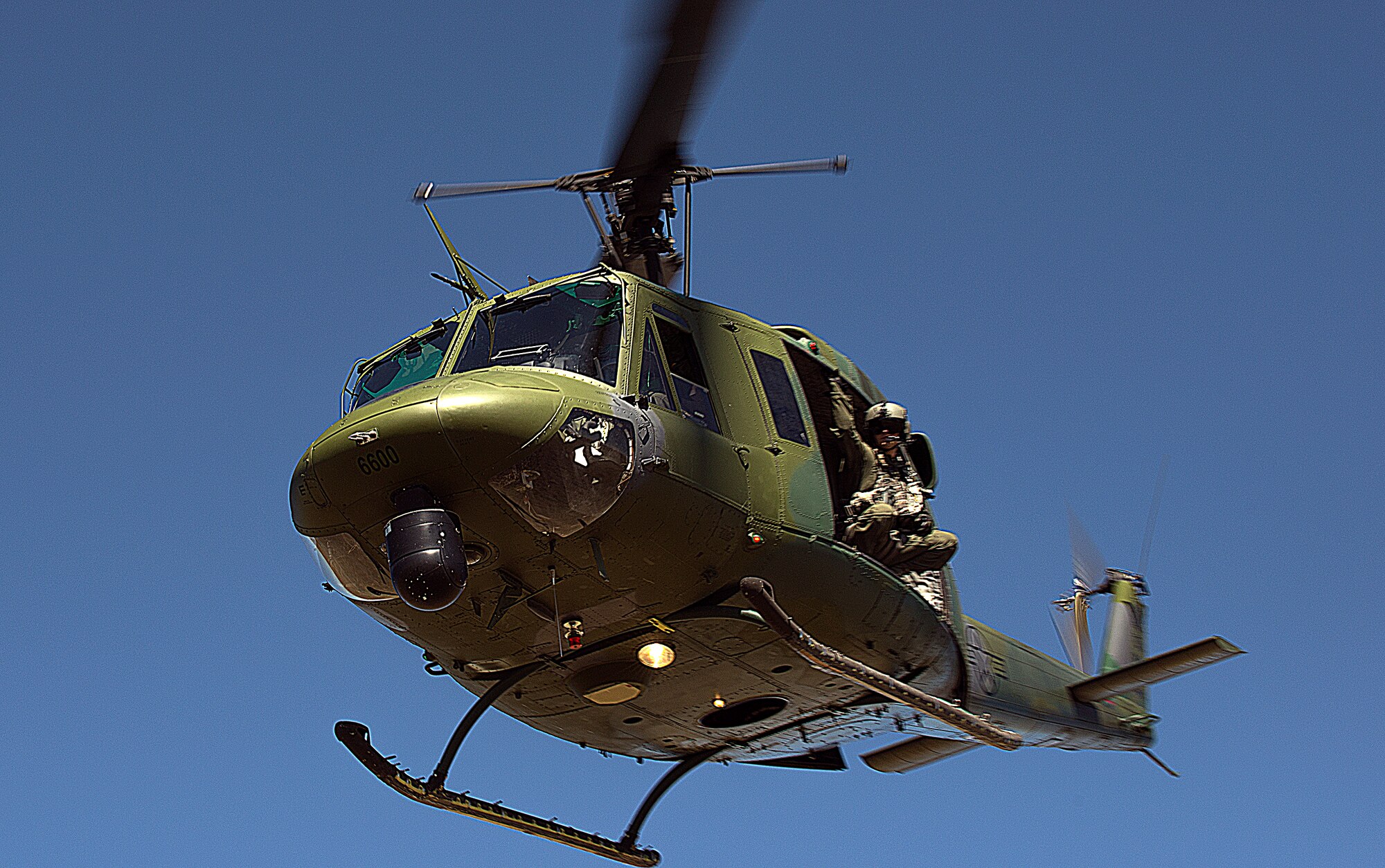 A flight engineer with F.E. Warren Air Force Base’s 37th Helicopter Squadron, scouts the terrain out the doors of a UH-1N Huey helicopter during a launch facility recapture exercise of the 2015 Global Strike Challenge Aug. 10, 2015. Crews had to navigate the Wyoming terrain, distinguish hostiles and insert a security forces tactical response force Airmen before capturing the launch facility south of Wheatland, Wyo. (U.S. Air Force photo by Airman 1st Class Brandon Valle)
