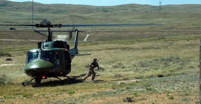 A 790th Missile Security Forces Squadron Tactical Response Force Airman from F.E. Warren Air Force Base, Wyo., jumps out of a 37th Helicopter Squadron UH-1N Huey helicopter and runs towards the gate of a deactivated Peacekeeper launch facility near Wheatland, Wyo., to end the timed portion of an LF recapture exercise Aug. 10, 2015, during the helicopter operations portion of the 2015 Global Strike Challenge. During the recapture exercise, teams were required to survey the area, tactically insert a TRF member to take out any “hostilities,” and then land near the LF to signify the final recapture. (U.S. Air Force photo by Airman 1st Class Brandon Valle/Released)