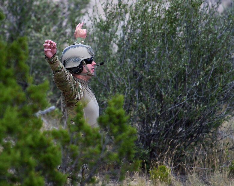 Airman 1st Class William Barron, 791st Missile Security Forces Squadron, signals his Minot Air Force Base teammates, Airmen of the 54th Helicopter Squadron as they fly their UH-1N Huey helicopter searching for him at Camp Guernsey, Wyo., Aug. 9, 2015. The Minot team was taking part in the 2015 Global Strike Challenge helicopter competition. (U.S. Air Force photo by R.J. Oriez/Released)