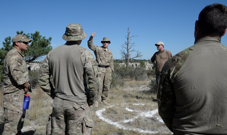 Evaluators brief Airmen taking part in the 2015 Global Strike Challenge helicopter competition at the start of the search and rescue event Aug. 9, 2015 in Camp Guernsey Wyo. The circle on the ground marks the spot helicopter crews need to hit with their penetrator when they lower if from their aircraft to pick up their teammates from the ground. (U.S. Air Force photo by R.J. Oriez/Released)