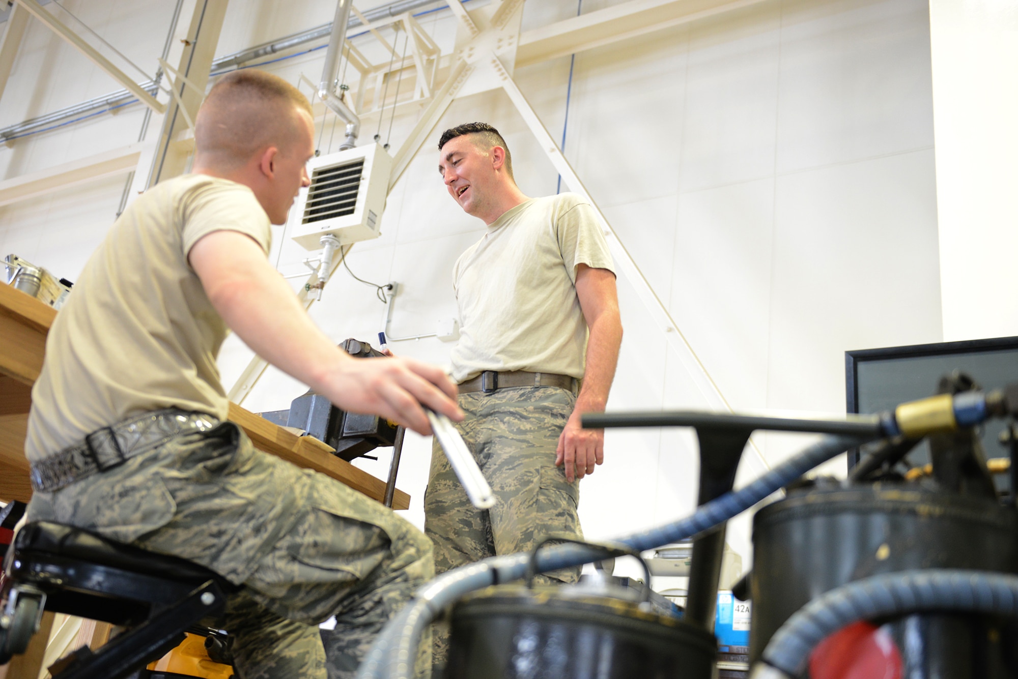Staff Sgt. Sean Barrett and Airman 1st Class Casey Beaty, 374th Maintenance Squadron aerospace ground equipment technicians, discuss methods for maintaining an oil cart at Yokota Air Base, Japan, Aug. 12, 2015. AGE inspects hundreds of pieces of equipment that are essential to ensuring an aircraft's mission readiness. (U.S. Air Force photo by Senior Airman David C. Danford/Released)