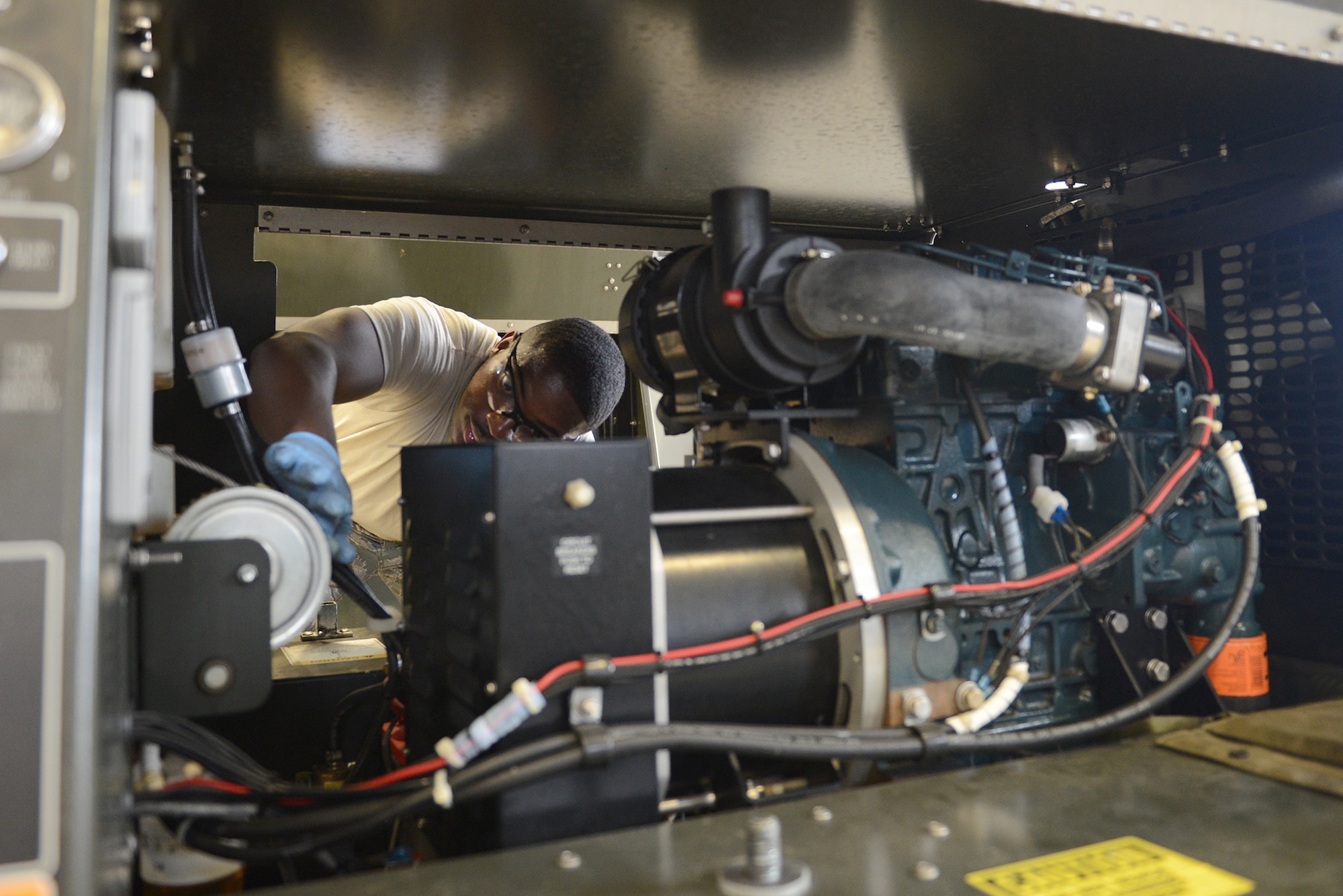 Airman 1st Class Kelsey Patterson, 374th Maintenance Squadron aerospace ground equipment journeyman, applies grease to a generator's moving parts at Yokota Air Base, Japan, Aug. 12, 2015. AGE Airmen are responsible for maintaining electrical generators, hydraulic testing units, aircraft jacking manifolds, maintenance stands and several other aircraft support systems.  (U.S. Air Force photo by Senior Airman David C. Danford/Released)