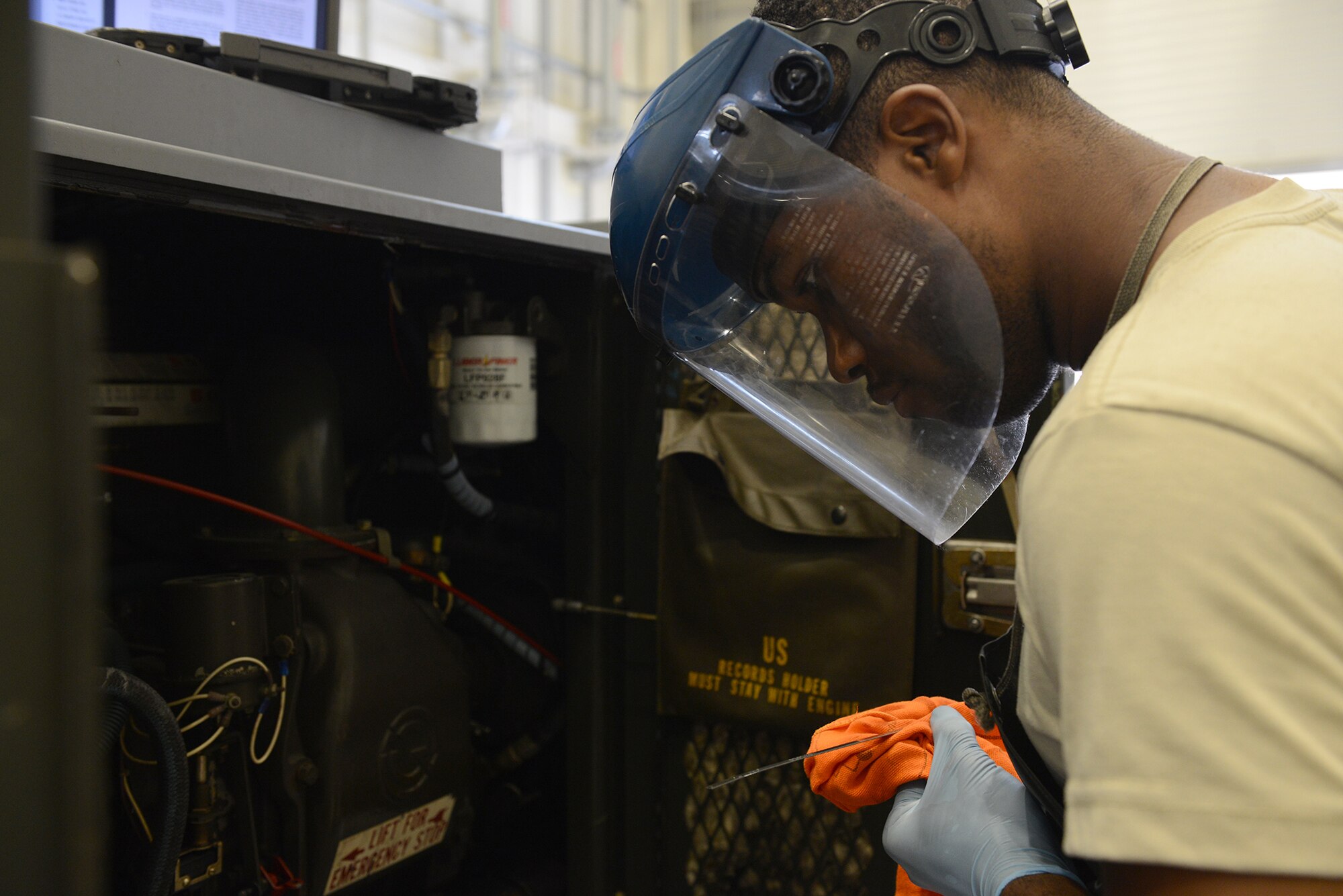 Senior Airman Demetrius Gray, 374th Maintenance Squadron aerospace ground equipment journeyman, performs a service inspection on a generator at Yokota Air Base, Japan, Aug. 12, 2015. AGE Airmen are responsible for maintaining electrical generators, hydraulic testing units, aircraft jacking manifolds, maintenance stands and several other aircraft support systems. (U.S. Air Force photo by Senior Airman David C. Danford/Released)