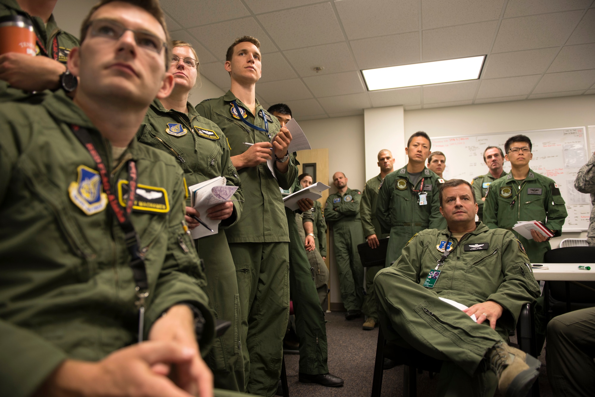 Members of the U.S. Air Force, Japan Air Self-Defense Force, Royal Australian Air Force and executive observers attend a mission briefing during Red Flag-Alaska at Joint Base Elmendorf-Richardson, Alaska, Aug. 10, 2015. Red Flag-Alaska is an exercise that provides joint offensive counter-air, interdiction, close air support and large force employment training in a simulated combat environment. More than 20 allied countries have participated in Red Flag-Alaska since its conception, improving integration, interoperability and cross-cultural competence. (U.S. Air Force photo by Staff Sgt. Cody H. Ramirez/Released)