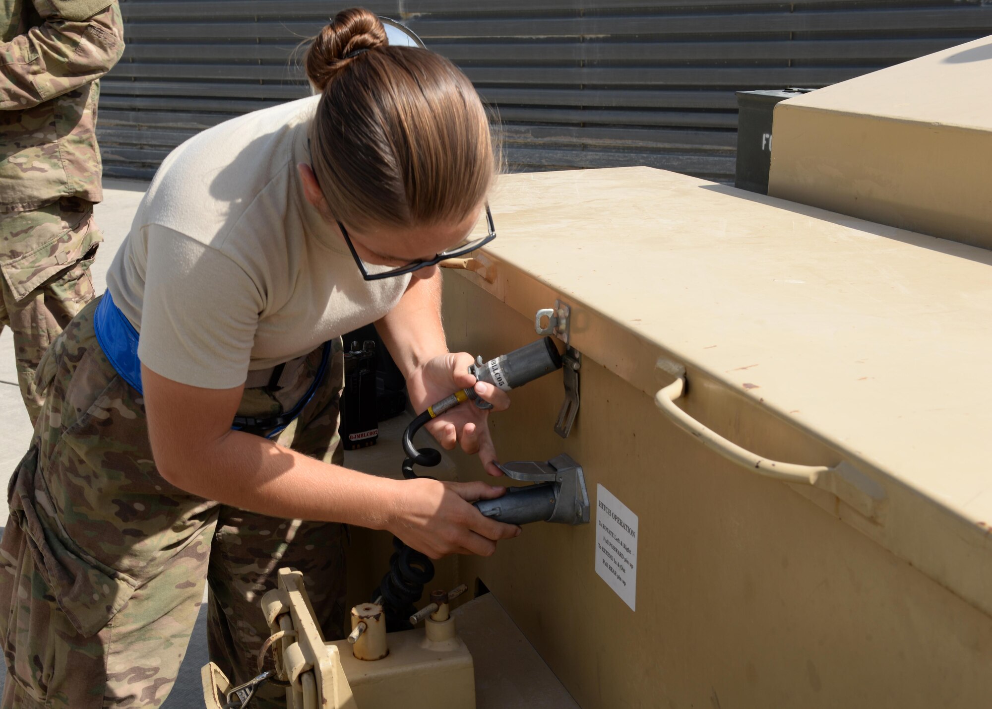 U.S. Air Force Airman First Class Morgan Strausser, 455th Expeditionary Maintenance Squadron line delivery crew chief, attaches a cable to a truck before delivering munitions to an F-16 Fighting Falcon aircraft Aug. 12, 2015, at Bagram Airfield, Afghanistan. Strausser is responsible for loading and unloading ammo from the F-16 Fighting Falcon aircraft here. (U.S. Air Force photo by Senior Airman Cierra Presentado/Released)