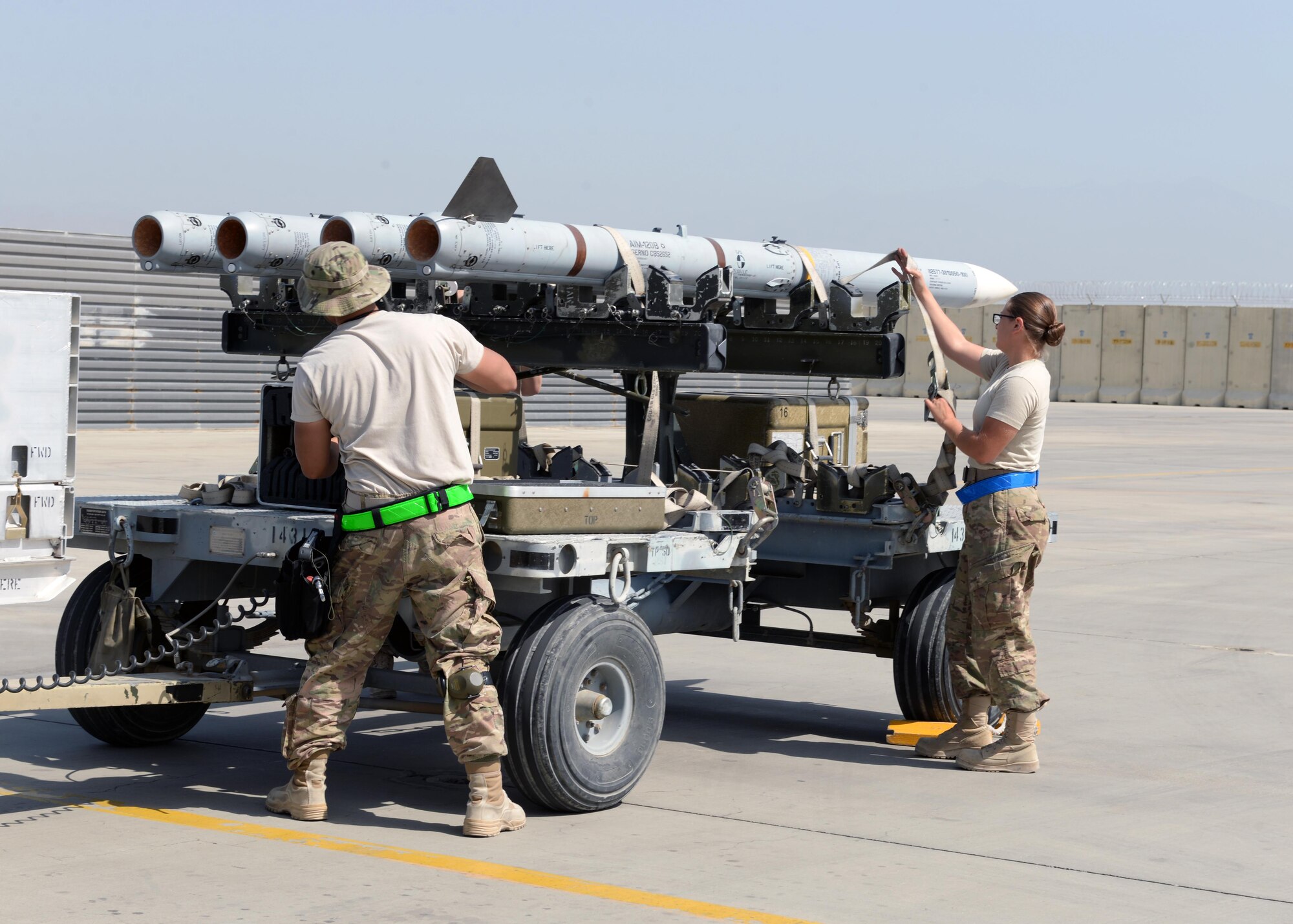 U.S. Air Force Airman First Class Morgan Strausser, 455th Expeditionary Maintenance Squadron line delivery crew chief and her team unload bombs from a trailer to transfer to an F-16 Fighting Falcon Aug. 12, 2015, at Bagram Airfield, Afghanistan. Strausser is responsible for loading and unloading ammo from the F-16 Fighting Falcon aircraft here. (U.S. Air Force photo by Senior Airman Cierra Presentado/Released)