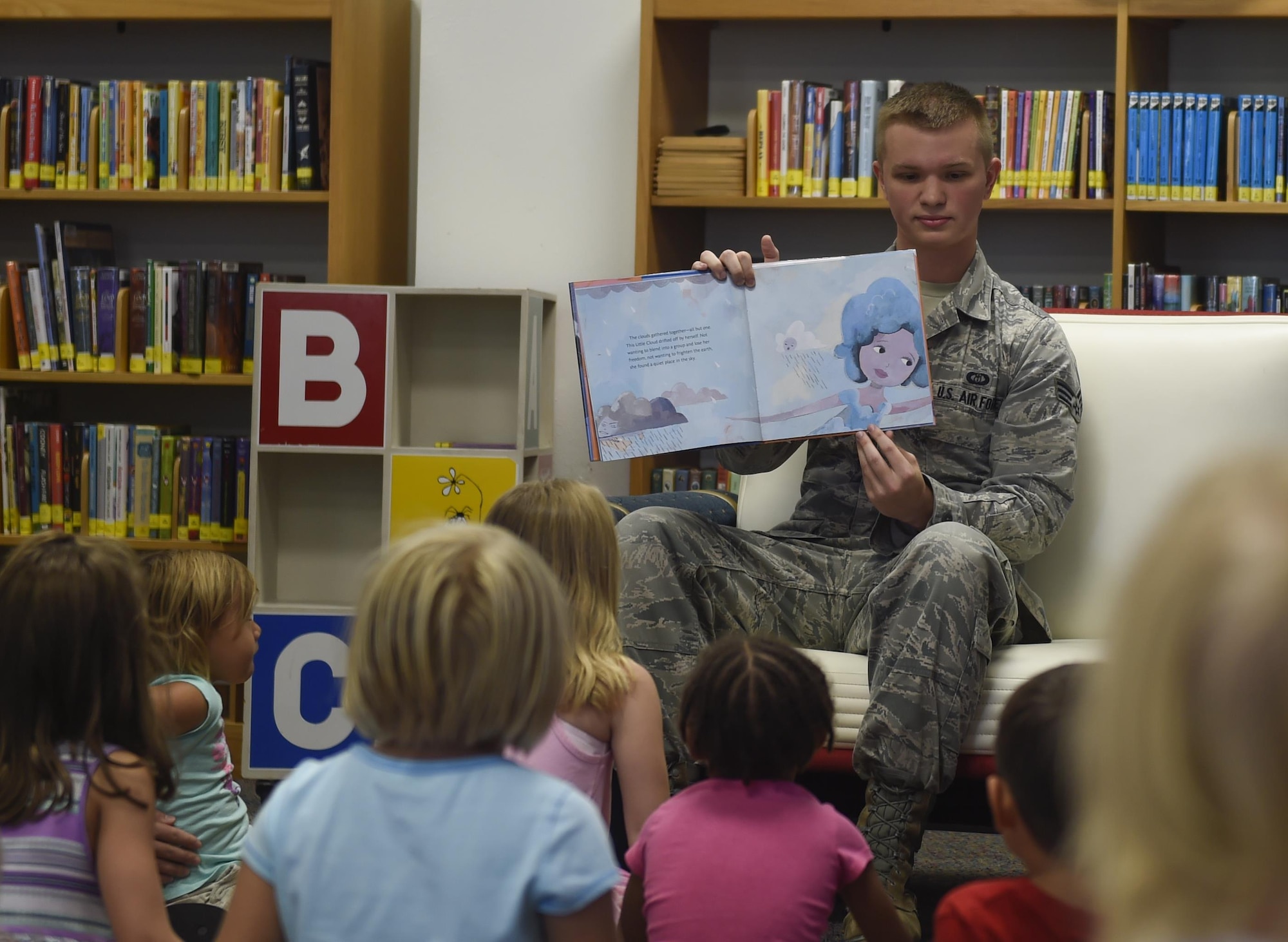 Senior Airman John Connor, 23rd Special Operations Weather Squadron weather technician, reads to children at the library on Hurlburt Field, Fla., Aug. 6, 2015. This week’s story time was led by Airmen from the 23rd SOWS as part of a scheduled, tri-annual visit to help teach children about weather systems. (U.S. Air Force photo by Airman Kai White/Released)