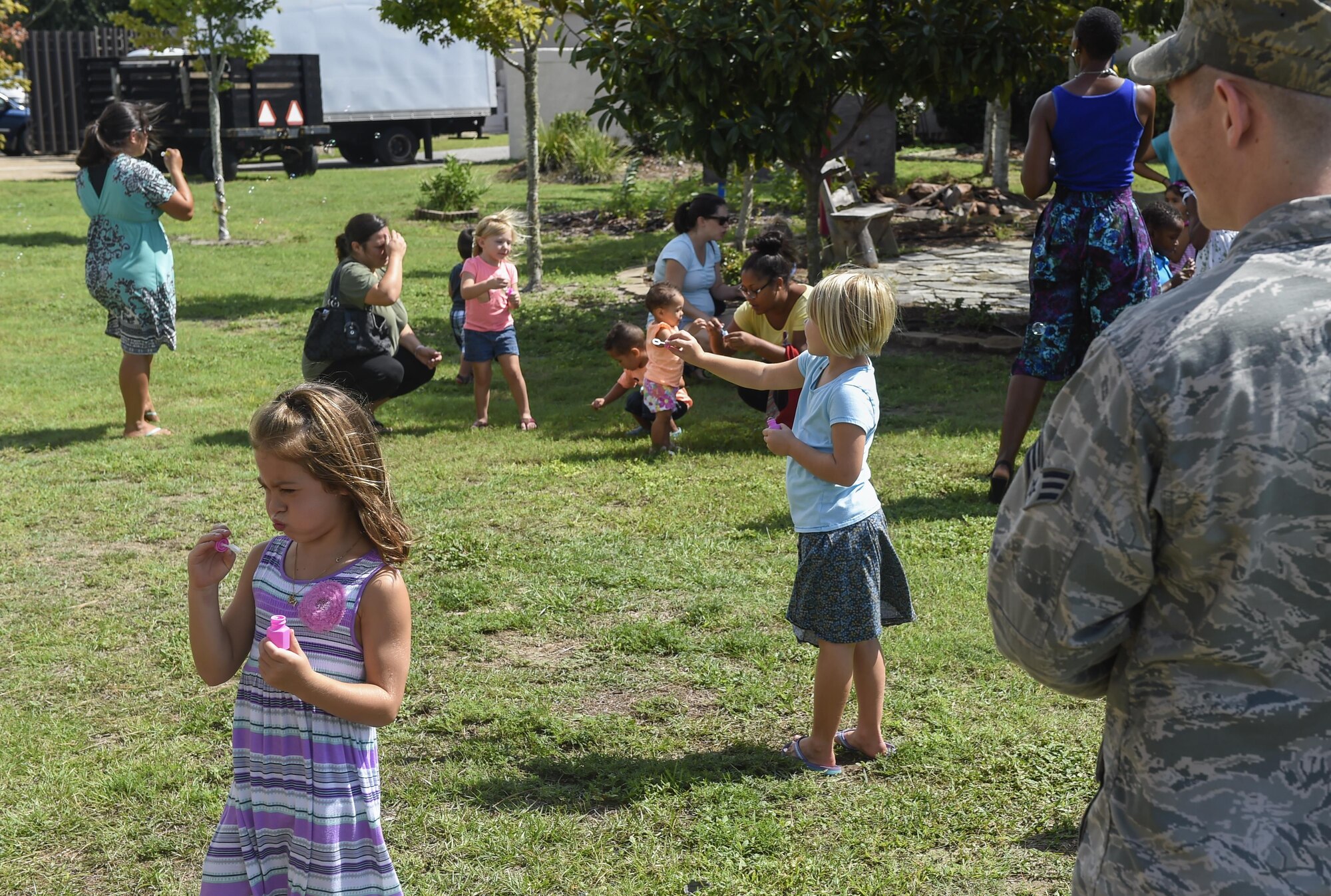 Children blow bubbles during story time at the library on Hurlburt Field, Fla., Aug. 6, 2015. During the library’s weekly story time, Airmen with the 23rd Special Operations Weather Squadron used a bubble demonstration to provide children with a simple, hands-on example of how wind systems work. (U.S. Air Force photo by Airman Kai White/Released)