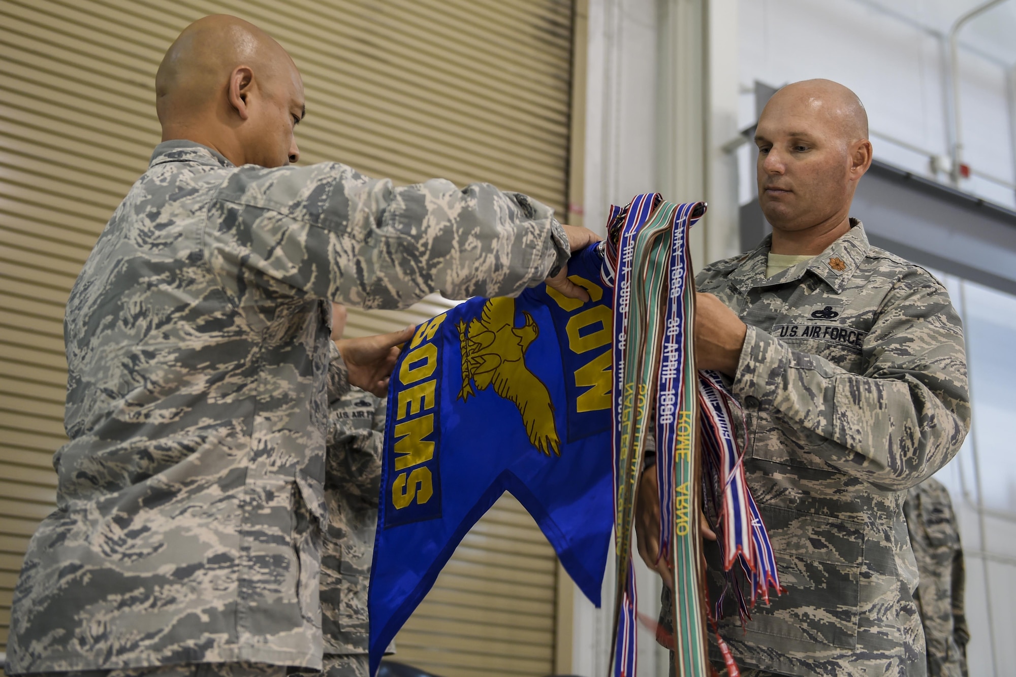 Colonel Rene M. Leon, 1st Special Operations Maintenance Group commander, and Maj. Jonathan E. Izworski, former 1st Special Operations Equipment Maintenance Squadron commander, furls the 1st SOEMS guidon during its deactivation ceremony, Aug. 10, 2015, at Hurlburt Field, Fla. During the ceremony, the 1st Special Operations Component Maintenance Squadron and the 1st Special Operations Equipment Maintenance Squadron deactivated and formed the newly activated 1st SOMXS. (U.S. Air Force photo by Airman 1st Class Ryan Conroy/Released)