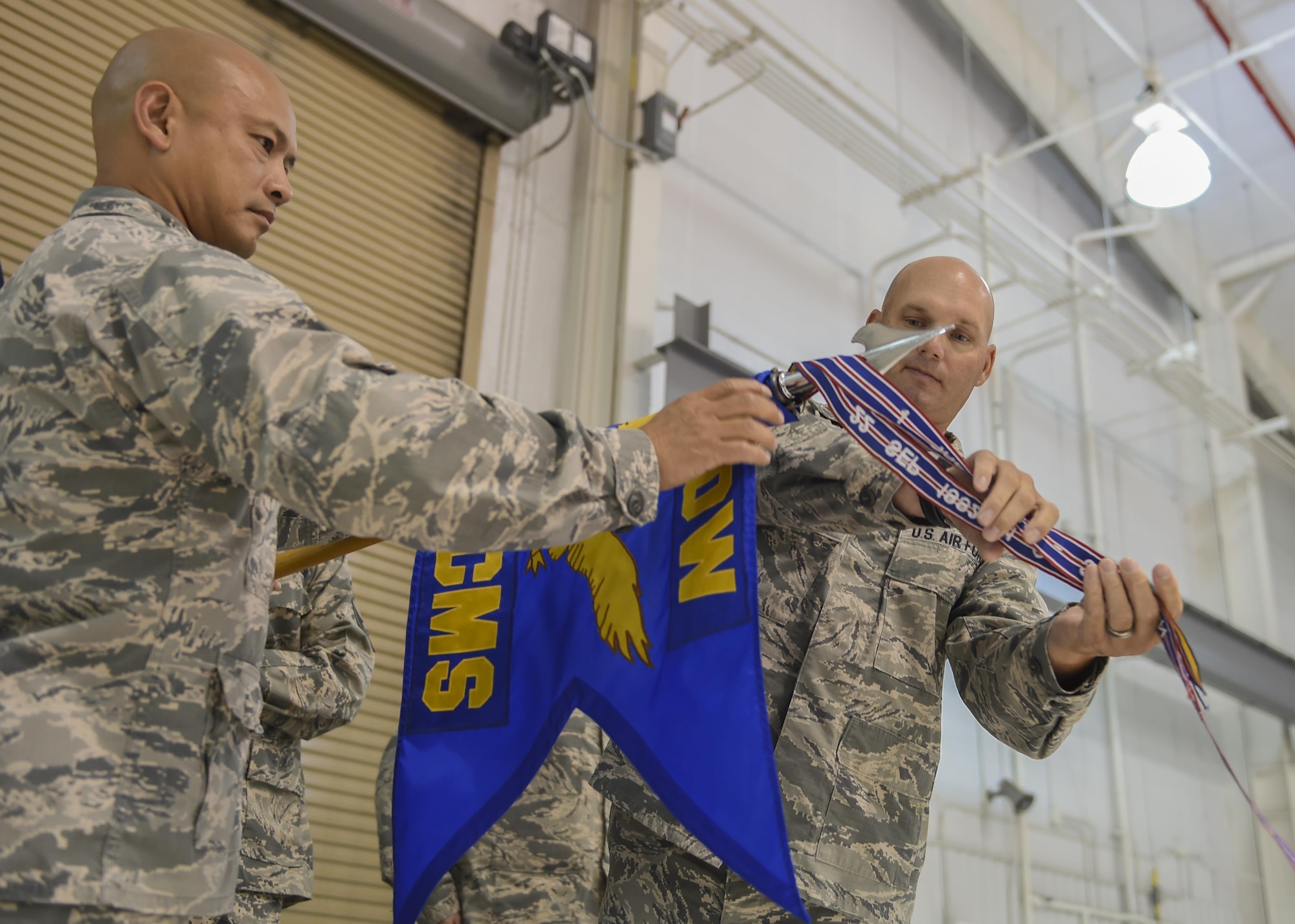 Colonel Rene M. Leon, 1st Special Operations Maintenance Group commander, and Maj. Jonathan E. Izworski, former 1st Special Operations Component Maintenance Squadron commander, furl the 1st SOCMS guidon during its deactivation ceremony, Aug. 10, 2015, at Hurlburt Field, Fla. During the ceremony, the 1st Special Operations Component Maintenance Squadron and the 1st Special Operations Equipment Maintenance Squadron deactivated and formed the newly activated 1st SOMXS. (U.S. Air Force photo by Airman 1st Class Ryan Conroy/Released)