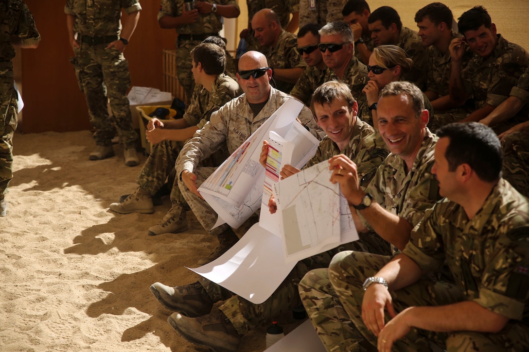 Marines with 2nd Marine Expeditionary Brigade along with their British and Canadian counterparts receive maps of a terrain model at a rehearsal of concept drill at Camp Wilson aboard Marine Corps Air Ground Combat Center Twentynine Palms, Calif., in support of the 2nd MEB Large Scale Exercise Aug. 12, 2015. LSE is a combined U.S. Marine Corps, Canadian, and British exercise conducted at the Brigade-level, designed to enable live, virtual and constructive training for participating forces.