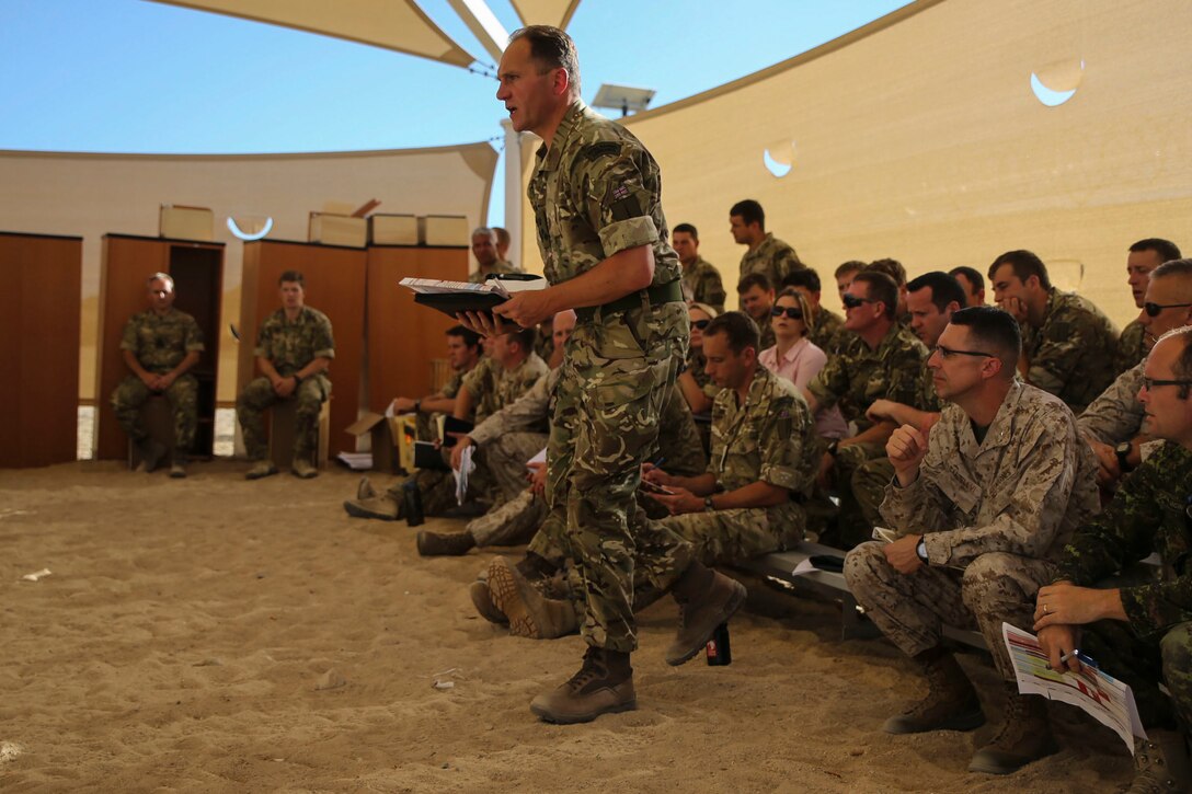 Brigadier Charlie Stickland RM steps forward into the terrain model to address the servicemembers at a rehearsal of concept drill at Camp Wilson aboard Marine Corps Air Ground Combat Center, Calif., in support of the 2nd MEB Large Scale Exercise Aug. 12, 2015. LSE is a combined U.S. Marine Corps, Canadian, and British exercise conducted at the Brigade-level, designed to enable live, virtual and constructive training for participating forces.