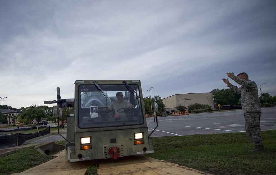 Tech Sgt. Matthew Fredericksen, 901st Special Operations Aircraft Maintenance Squadron assistant aircraft section chief, guides Staff Sgt. Jeffrey Minard, 901st SOAMXS dedicated crew chief, as Minard parks an MC-130P Combat Shadow at Hurlburt Field, Fla., Aug. 15, 2015. More than 40 personnel with eight base organizations were on site during the tow process. The MC-130P Combat Shadow known as “Team Shadow” will be displayed at the South end of the Air Park. (U.S. Air Force photo by Senior Airman Christopher Callaway/released)