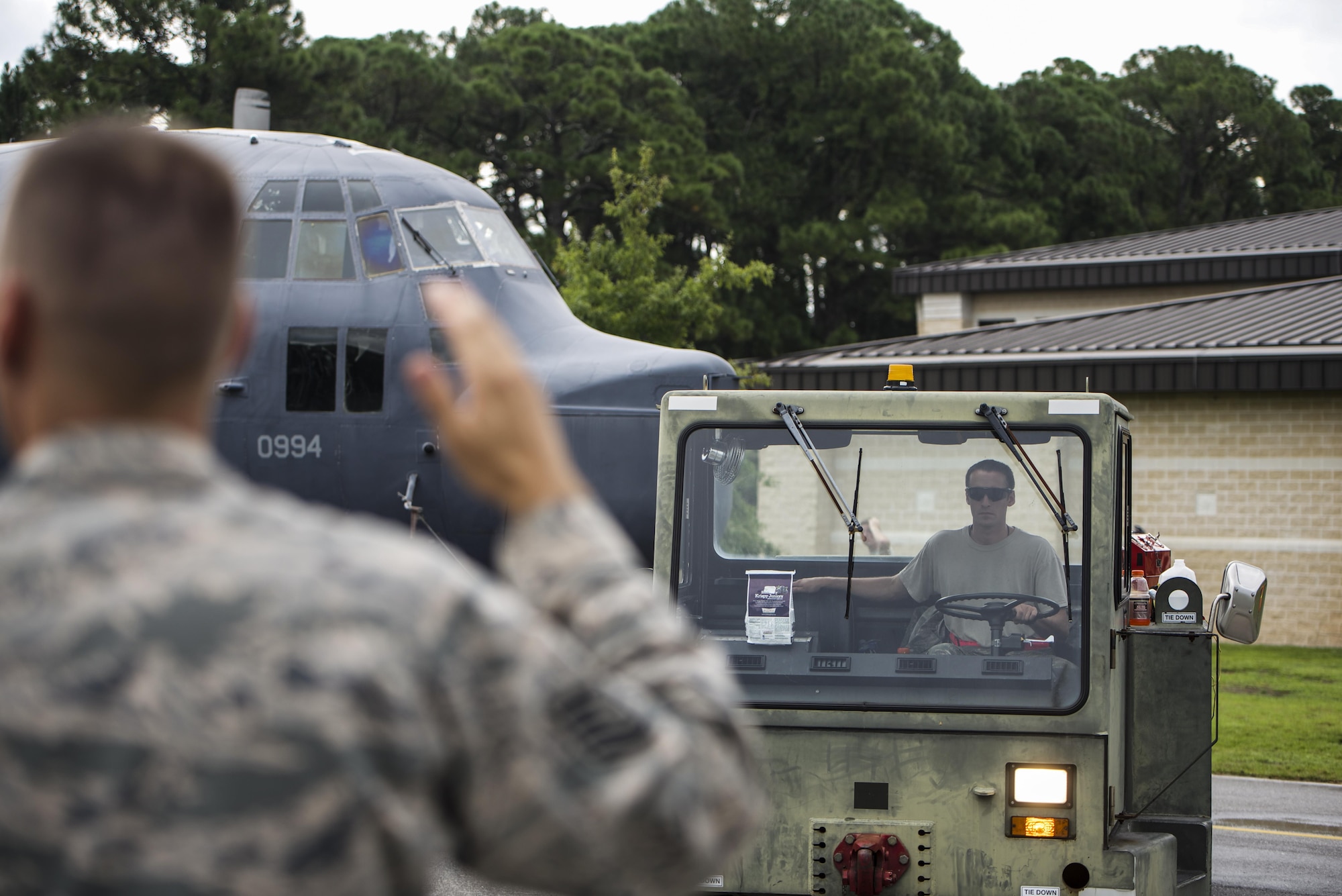 Tech Sgt. Matthew Fredericksen, 901st Special Operations Aircraft Maintenance Squadron assistant aircraft section chief, guides Staff Sgt. Jeffrey Minard, 901st SOAMXS dedicated crew chief, as Minard tows an MC-130P Combat Shadow at Hurlburt Field, Fla., Aug. 15, 2015. The Combat Shadow was staged for installation in the Hurlburt Field Air Park. The MC-130P fleet was retired May 15, 2015, after more than 25 years of service. The installation process for this aircraft known as “Team Shadow” is set to be complete by Sep. 6, 2015. (U.S. Air Force photo by Senior Airman Christopher Callaway/released)
