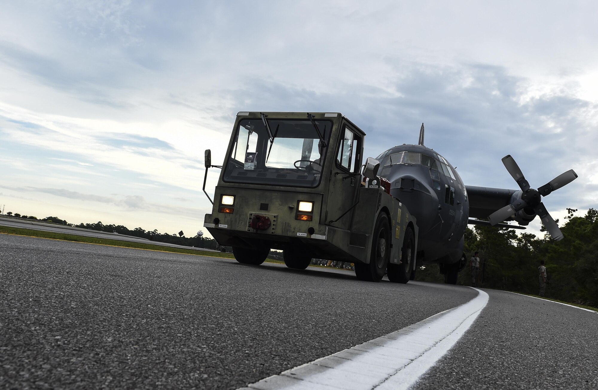 An MC-130P Combat Shadow is towed down Independence Road, Aug. 15, 2015, on Hurlburt Field, Fla. The Combat Shadow was towed from the flightline and staged for installation in the Hurlburt Field Air Park. The MC-130P fleet was retired May 15, 2015, after more than 25 years of service. The installation process for this aircraft known as “Team Shadow,” is scheduled for completion by Sept. 6, 2015. (U.S. Air Force photo by Airman 1st Class Ryan Conroy/Released) 
