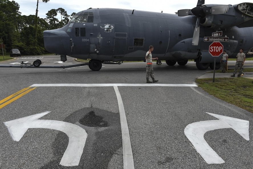 An MC-130P Combat Shadow is towed down Independence Road, Aug. 15, 2015, on Hurlburt Field, Fla. The Combat Shadow was towed from the flightline and staged for installation in the Hurlburt Field Air Park. The installation process for this aircraft known as “Team Shadow,” is scheduled for completion by Sept. 6, 2015. (U.S. Air Force photo by Airman 1st Class Ryan Conroy/Released)
