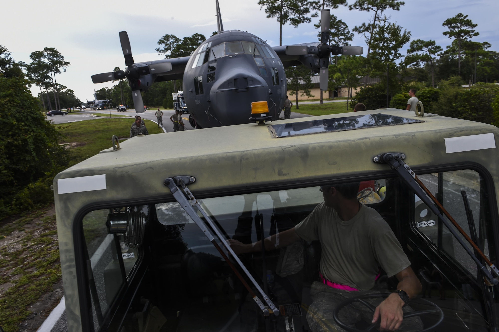 Staff Sgt. Jeffrey Minard, 901st Special Operations Aircraft Maitenance Squadron dedicated crew chief, tows an MC-130P Combat Shadow down Independence Road, Aug. 15, 2015, on Hurlburt Field, Fla. The Combat Shadow was towed from the flightline and staged for installation in the Hurlburt Field Air Park. The MC-130P fleet was retired May 15, 2015, after more than 25 years of service. The installation process for this aircraft known as “Team Shadow,” is scheduled for completion by Sept. 6, 2015. (U.S. Air Force photo by Airman 1st Class Ryan Conroy/Released)
