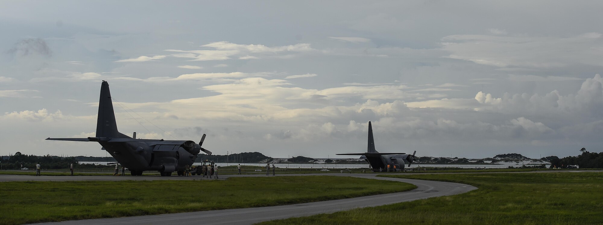 Airmen tow an AC-130H Spectre, left, and an MC-130P Combat Shadow, right, from the flightline to the Air Park on Hurlburt Field, Fla., August 15, 2015. More than 40 personnel with eight base organizations were on site during the tow process. The AC-130H Spectre will be displayed at the North end of the Air Park and the MC-130P Combat Shadow will be displayed at the South end of the Air Park. (U.S. Air Force photo by Airman Kai White/Released)