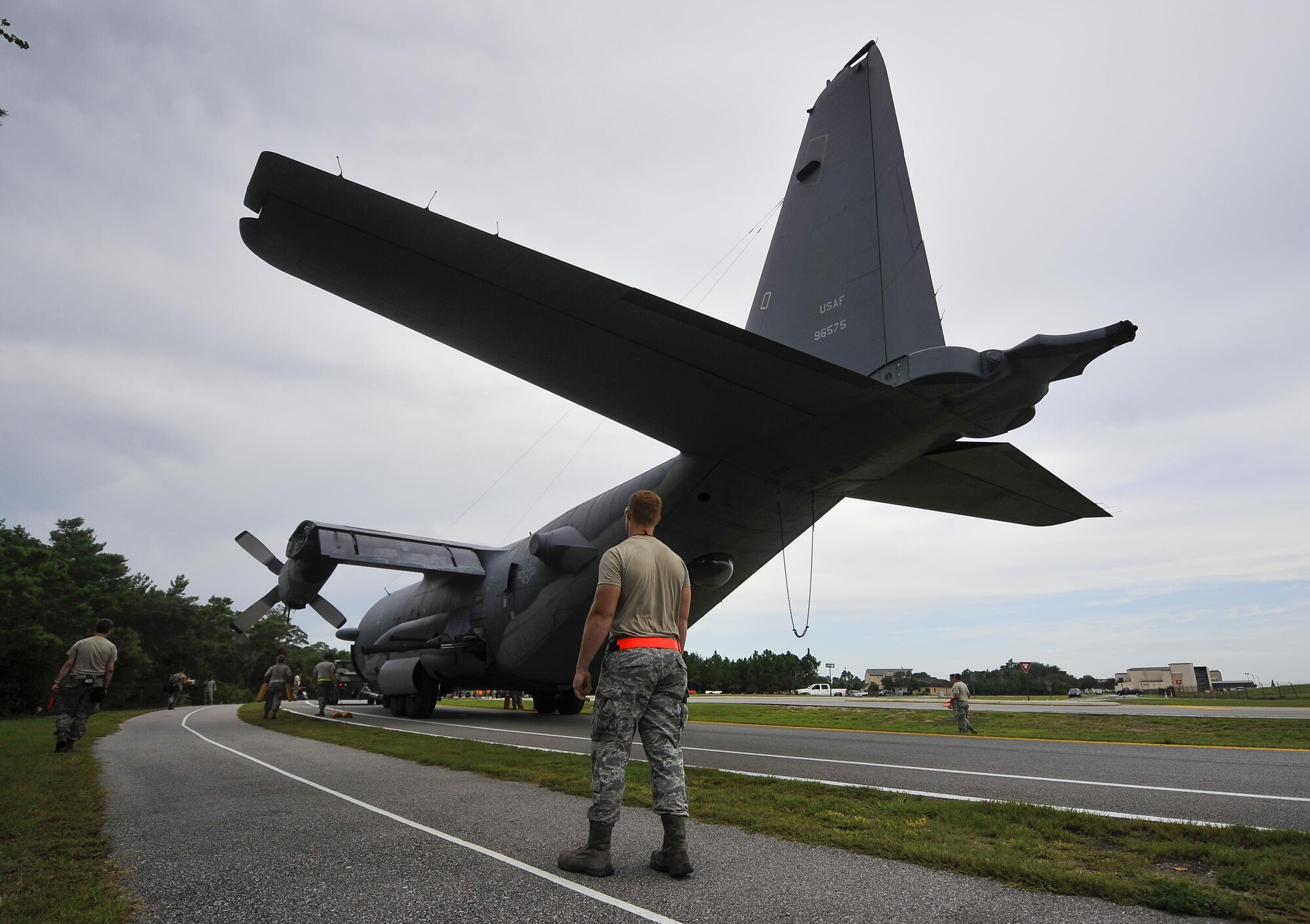 Airmen with the 1st Special Operations Aircraft Maintenance Squadron escort an AC-130H Spectre enroute to the Air Park on Hurlburt Field, Fla., Aug. 15, 2015. The Spectre was towed from the flightline and staged for installation in the Hurlburt Field Air Park. The AC-130H fleet retired May 26, 2015, after more than 45 years of service. The installation process for this aircraft, known as “Wicked Wanda,” is set to be complete by Aug. 28, 2015. (U.S. Air Force photo by Airman Kai White/Released)
