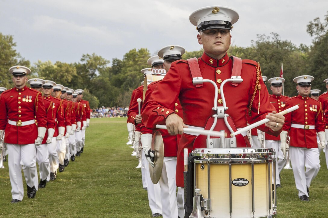Members of the U.S. Marine Drum and Bugle Corps perform during a sunset parade at the Marine Corps War Memorial in Arlington, Va., Aug 11, 2015. Since September 1956, marching and musical units from Marine Barracks Washington, D.C., have presented sunset parades in the shadow of the 32-foot high figures of the memorial.