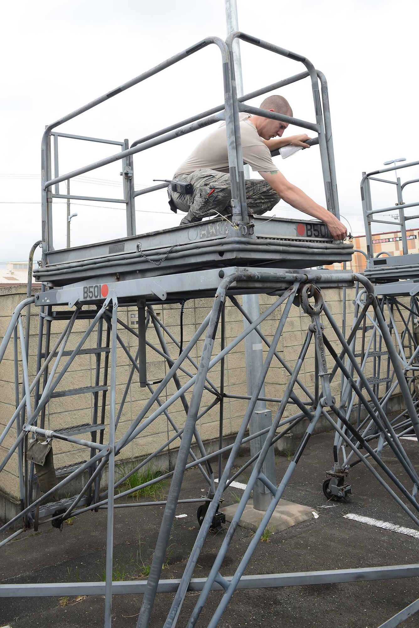 U.S. Air Force Airman 1st Class Matthew Hepler, 374th Maintenance Squadron aerospace ground equipment journeyman, ensures that brakes and latches are secured on a maintenance stand at Yokota Air Base, Japan, Aug. 12, 2015. AGE Airmen are responsible for ensuring that all equipment on the flightline are serviceable and ready for use according to regulations. (U.S. Air Force photo by Senior Airman David C. Danford/Released)