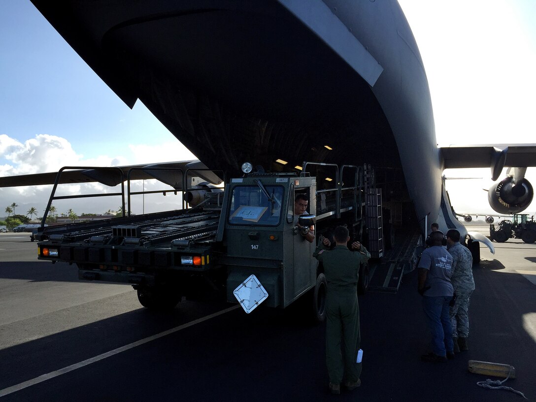 A U.S. Air Force 535th Airlift Squadron load master directs a K-loader aboard a U.S. Air Force C-17 Globemaster III bound for Saipan, Aug. 8, 2015, Joint Base Pearl Harbor-Hickam, Hawaii. Pacific Air Forces is supporting a U.S. response committed to assisting in the recovery efforts and ensuring that the people of Saipan have the necessary means to rebuild and be self-sustaining. (U.S. Air Force courtesy photo/Released)