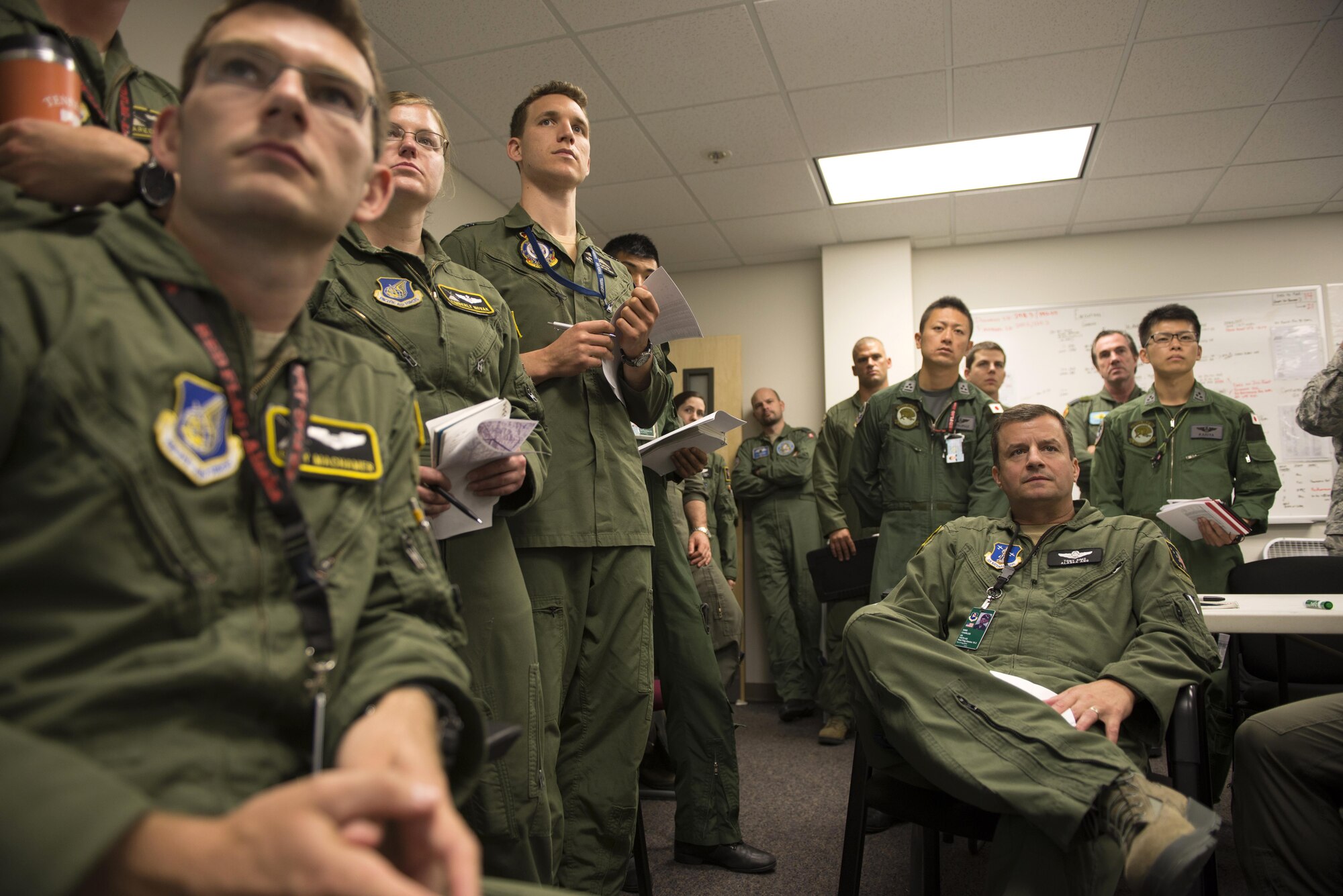 Members of the U.S. Air Force, Japan Air Self-Defense Force, Royal Australian Air Force and executive observers attend a mission briefing during Red Flag-Alaska at Joint Base Elmendorf-Richardson, Alaska, Aug. 10, 2015. Red Flag-Alaska is an exercise that provides joint offensive counter-air, interdiction, close air support and large force employment training in a simulated combat environment. More than 20 allied countries have participated in Red Flag-Alaska since its conception, improving integration, interoperability and cross-cultural competence. (U.S. Air Force photo by Staff Sgt. Cody H. Ramirez/Released)