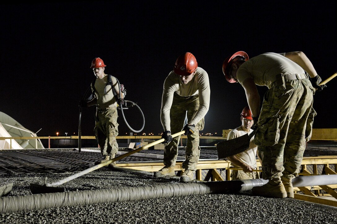 Airmen assigned to the 557th Expeditionary RED HORSE Squadron form the top of a concrete roof on a structure at an undisclosed location in Southwest Asia July 28, 2015. RED HORSE is a self-sustaining, mobile, heavy construction squadron capable of rapid response and independent operations in remote, high-threat environments worldwide. (U.S. Air Force photo/Tech. Sgt. Christopher Boitz)