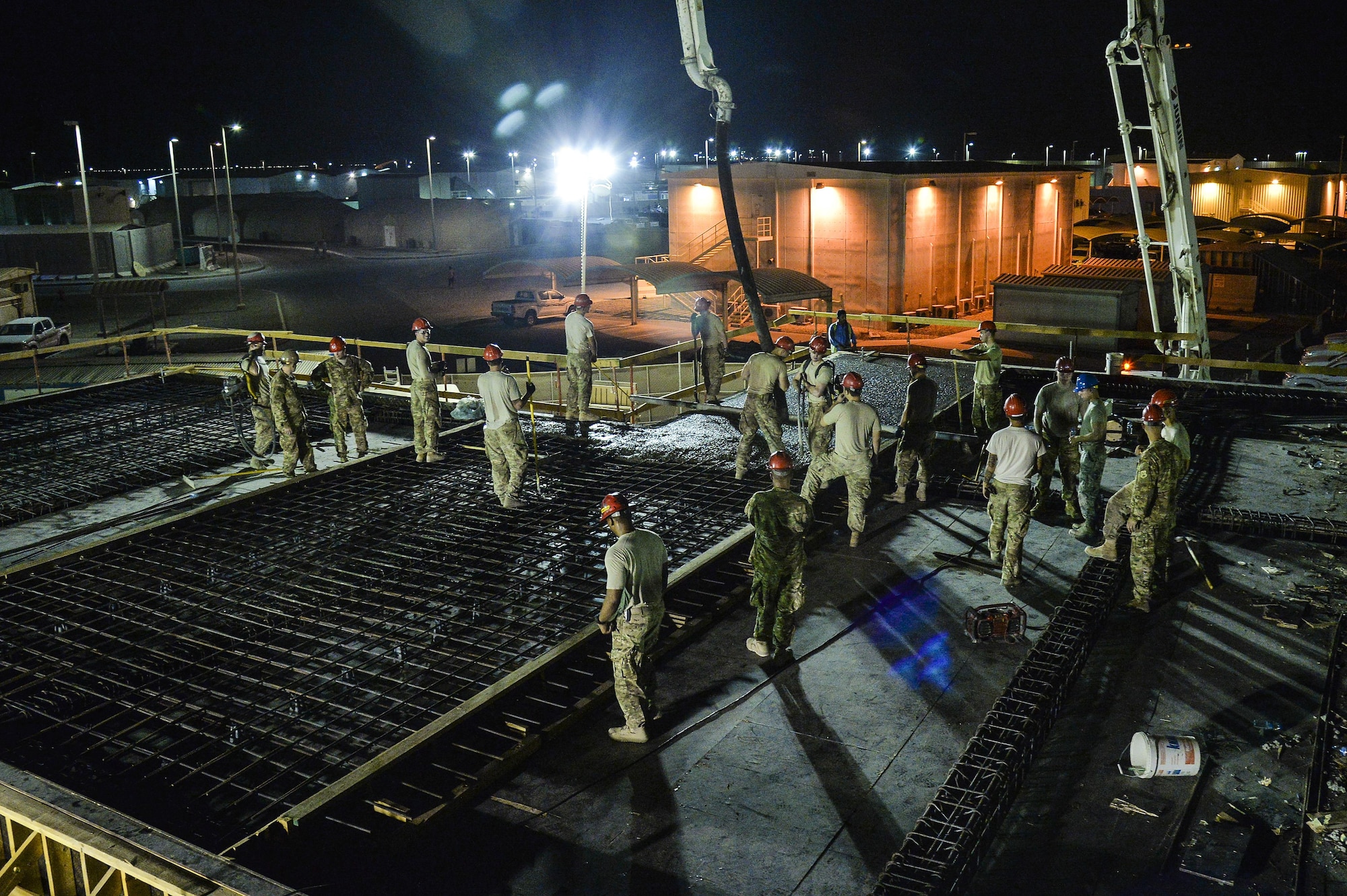 Airmen assigned to the 557th Expeditionary RED HORSE Squadron pour concrete roof on a structure at an undisclosed location in Southwest Asia July 28, 2015. RED HORSE is a self-sustaining, mobile, heavy construction squadron capable of rapid response and independent operations in remote, high-threat environments worldwide. (U.S. Air Force photo/Tech. Sgt. Christopher Boitz)