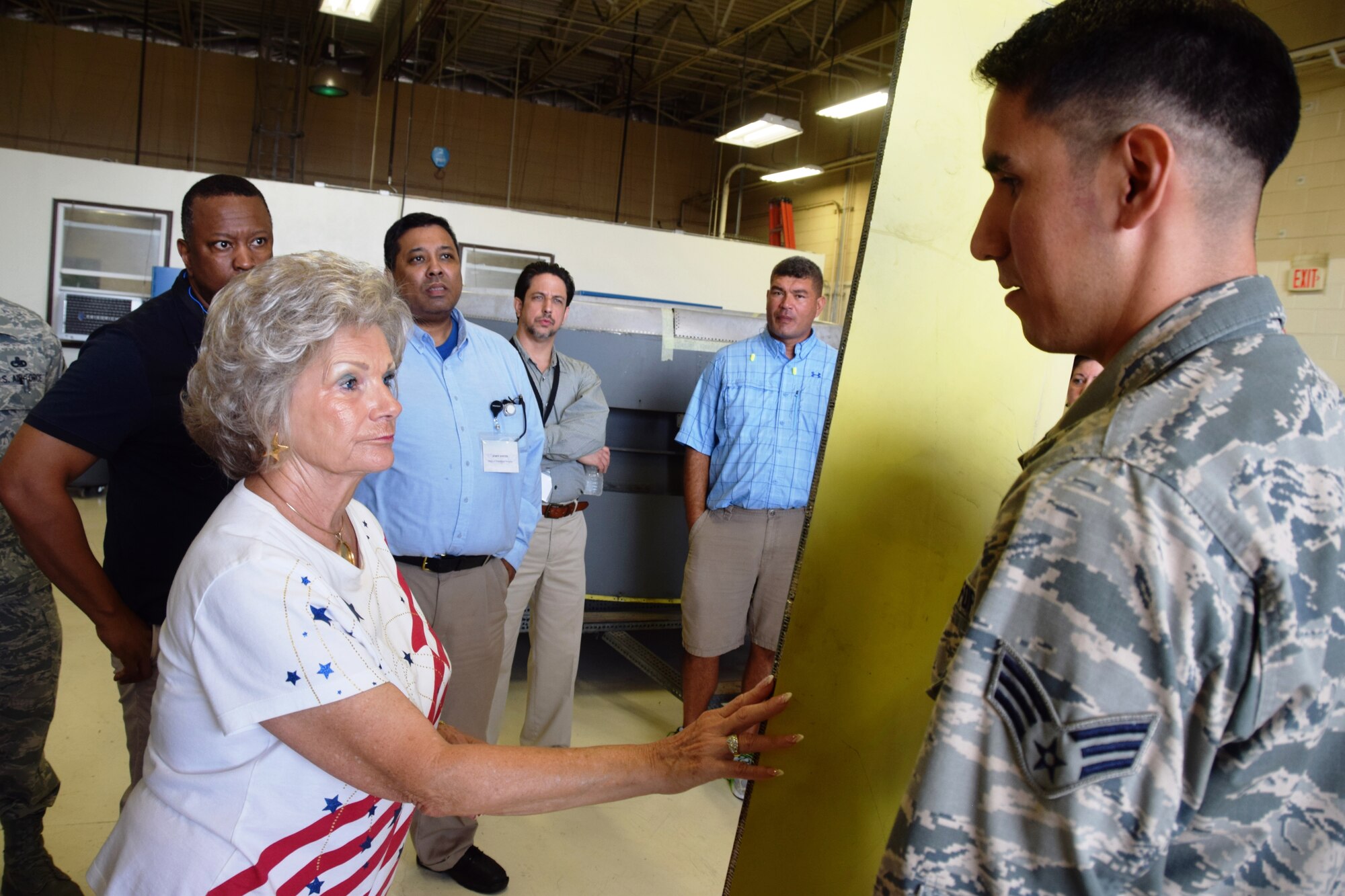 Janice Ricks, honorary commander for the 433rd Operations Support Squadron, inspects a piece of material used to repair aircraft held by Senior Airman Ivan Vela, a structural repair technician with the 433rd Maintenance Squadron, on Aug. 15, 2015 at Joint Base San Antonio-Lackland, Texas.  The group toured a static of a C-5A Galaxy on the flightline and visited the maintenance shops to learn how Reservists contribute to the Air Force mission. (U.S. Air Force photo by Tech. Sgt. Carlos J. Trevino)