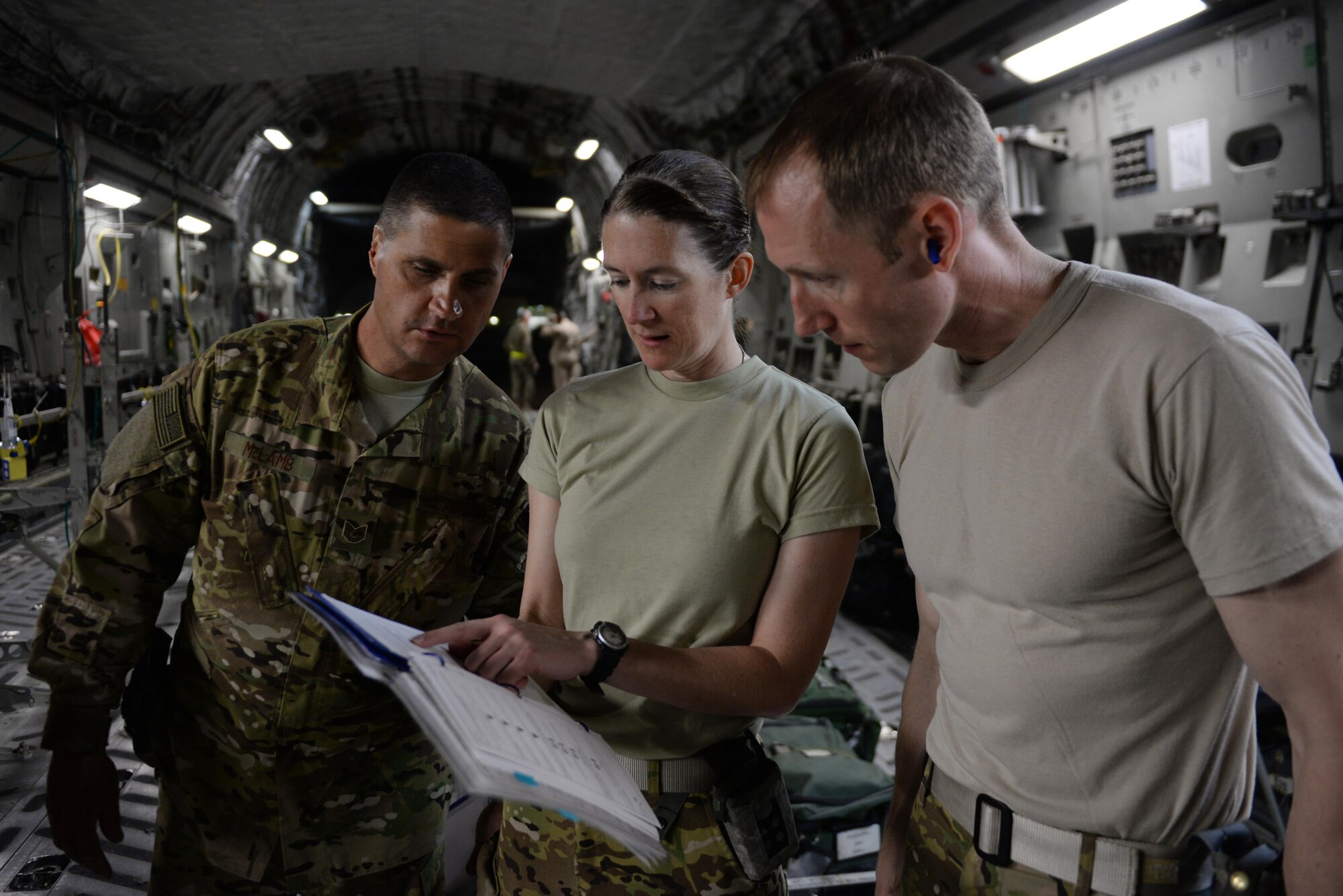 U.S. Air Force Senior Airman Margaret “Maggie” Mathewes, center, 455th Expeditionary Aeromedical Evacuation Squadron AE technician deployed from the Air Force Reserve’s 315th Aeromedical Evacuation Squadron at Joint Base Charleston, South Carolina , reviews an AE checklist with Tech. Sgt. Russell “Rusty” McLamb, left, 455th Expeditionary Aeromedical Evacuation Squadron AE technician deployed from the North Carolina Air National Guard’s 156th AES,  and Capt. Derek Martindale, right, 455th EAES flight nurse deployed from the 315th AES, prior to loading patients onto a C-17 Globemaster III aircraft at Bagram Airfield, Afghanistan, Aug. 8, 2015.  The 455th EAES Airmen are charged with the responsibility of evacuating the sick and wounded from Central Command to higher echelons of medical care. (U.S. Air Force photo by Maj. Tony Wickman/Released)