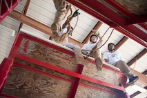 From left: Lieutenants Carnell Mills, Mat Mara and Robin Chapman, members of the Montgomery Police Department, work through an obstacle at the Leadership Reaction Course at Maxwell Air Force Base, Ala., Aug. 7, 2015. The reaction course is an Officer Training School leadership building tool, designed to teach participants how to apply leadership principles and theory from the classroom in a problem-solving scenario. The police officers were attending a new two-day leadership consortium in partnership with OTS faculty. (U.S. Air Force photo by Tech. Sgt. Sarah Loicano)