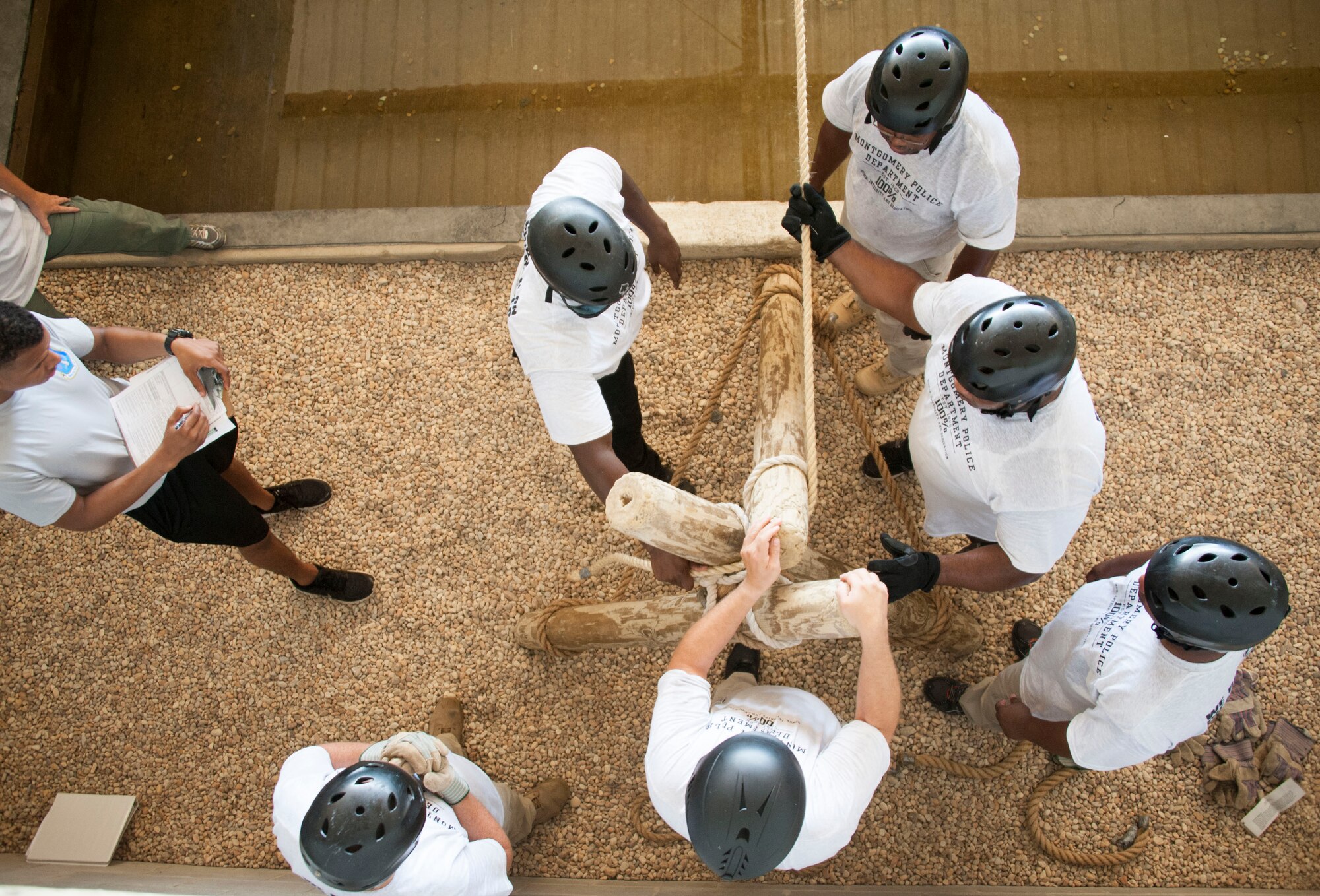 Capt. Kris Walker, chief of training at Officer Training School, evaluates members of the Montgomery Police Department as they attempt an obstacle challenge at the Leadership Reaction Course at Maxwell Air Force Base, Alabama, Aug. 7, 2015. The police officers were participating in a new leadership consortium exchange with OTS faculty to learn and apply leadership concepts both in the classroom and field environments. (U.S. Air Force photo by Tech. Sgt. Sarah Loicano)