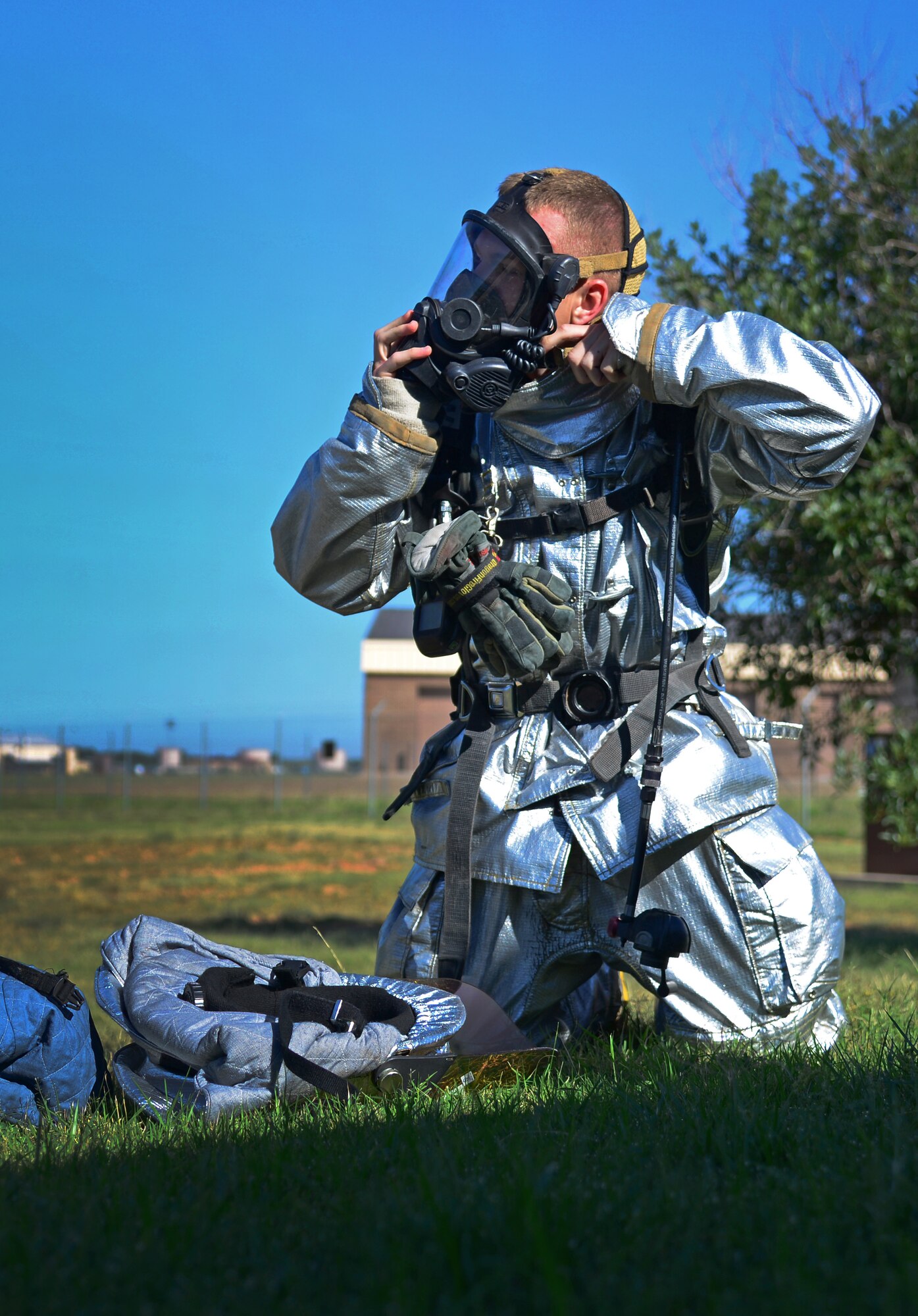An Air Commando with the 27th Special Operations Civil Engineer Squadron secures his mask while gearing up during an exercise Aug. 4, 2015 at Cannon Air Force Base, N.M. Seasoned emergency responders planned a mock fire response scenario at the munitions storage area, challenging crews to quickly access the situation and safely clear staged facilities. (U.S. Air Force photo/Staff Sgt. Alexx Mercer) 