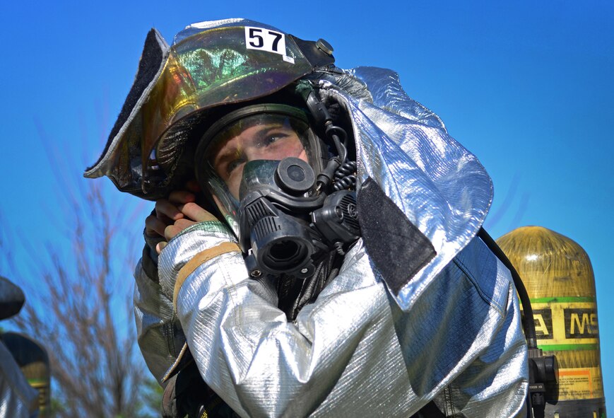 An Air Commando with the 27th Special Operations Civil Engineer Squadron fastens his protective headgear during an exercise Aug. 4, 2015 at Cannon Air Force Base, N.M. Seasoned emergency responders planned a mock fire response scenario at the munitions storage area, challenging crews to quickly access the situation and safely clear staged facilities. (U.S. Air Force photo/Staff Sgt. Alexx Mercer)